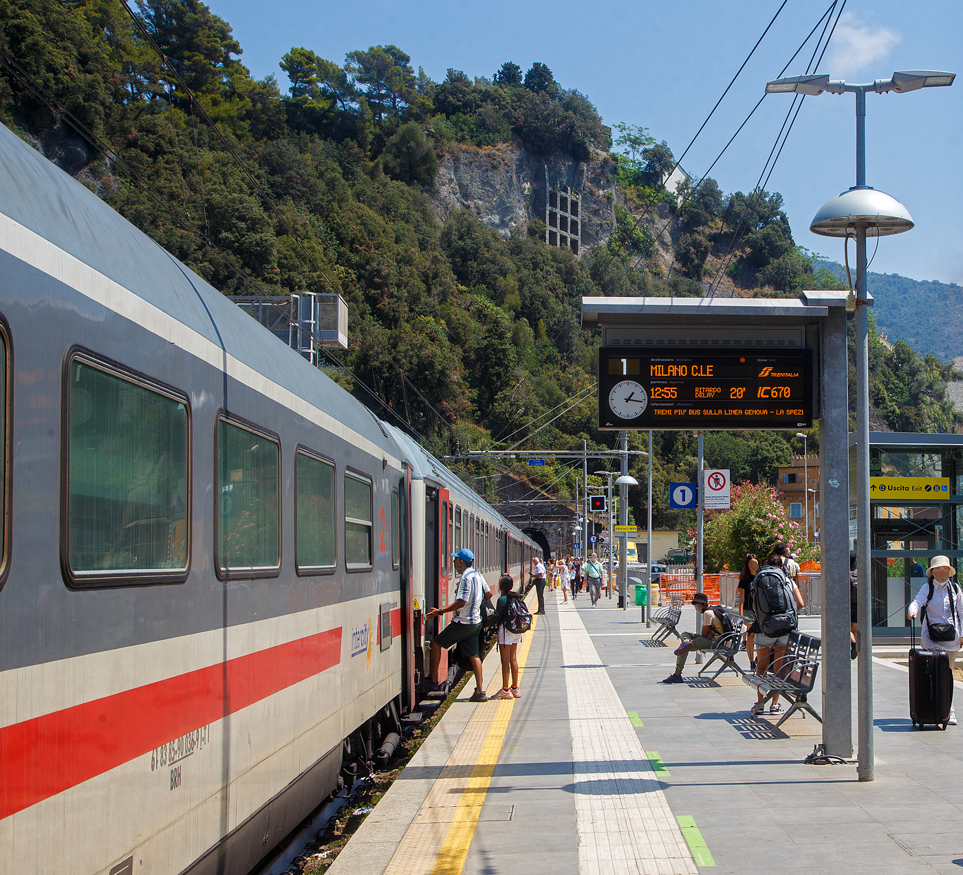 Der Bahnhof Monterosso Cinque Terre (komplette Bezeichnung der Gemeide Monterosso al Mare) an der Italienischen Riviera. Von den Cinque Terre Bahnhöfen hat Monterosso die längsten Bahnsteige unter freiem Himmel, so halten hier auch Intercity-Züge. 

Das Fischerdorf Monterosso al Mare ist das nördlichste Dorf und mit rund 1700 Einwohnern der größte Ort der Cinque Terre an der Italienischen Riviera. Monterosso erstreckt sich über rund 1,5 Kilometer und ist zweigeteilt, die kleine Altstadt ist vom neueren Viertel Fegina durch einen ins Meer ragenden Felsen getrennt, auf dem sich der markante Wachtturm Torre Aurora aus dem 16. Jahrhundert erhebt. Durch den Felsen führt ein rund 100 m langer Fußgängertunnel.

Hier hält am 22.07.2022 gerade, im Sandwich zweier E.414 (ehemalige Triebköpfe E.404 A der ersten ETR 500 – Monotensione), der Trenitalia InterCity IC 670 (Livorno – Pisa - La Spezia - Monterosso - Genova - Milano Centrale), im Cinque Terre Bahnhof Monterosso.