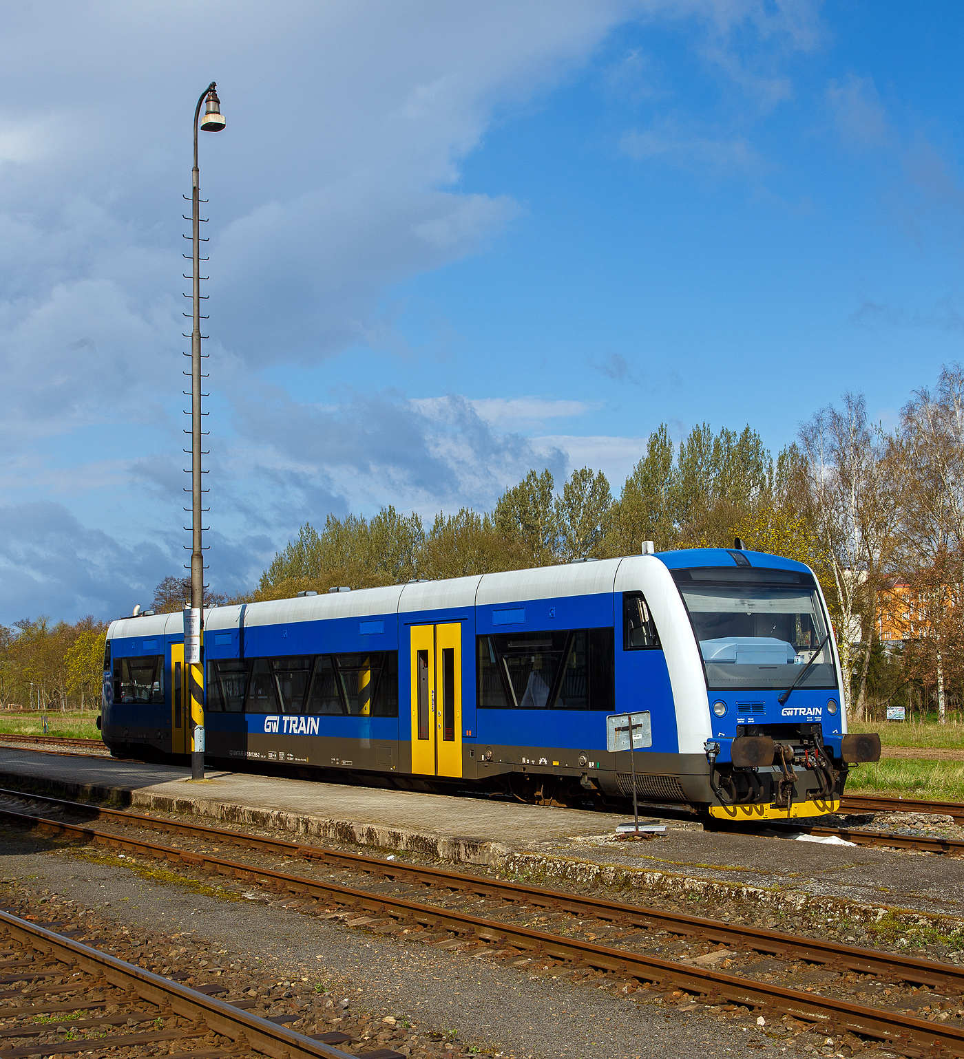 Der blaue STADLER Regio-Shuttle RS1 bzw. RegioSpider 841 265-2 (95 54 5841 265-2 CZ-GWTR) der GW Train Regio a.s. hat am 19.04.2023 von Mariánské Lázně (Marienbad) kommend den Bahnhof Karlovy Vary dolní nádraží (Karlsbad untere Bahnhof) erreicht und steht gleichauf zur Rückfahrt bereit. 

Der STADLER Regio-Shuttle RS1 wurde 1998 von ADtranz (ABB Daimler-Benz Transportation GmbH) in Berlin (heute Stadler Pankow) unter der Fabriknummer 36784 gebaut und als BOB VT 65 an die Bodensee-Oberschwaben-Bahn geliefert, von 2007 bis 2021 lief er unter der NVR-Nr. 5 80 0650 355-0 D-BOBFN. Im Jahr 2021 wurde er an die GW Train Regio a.s. nach Tschechien verkauft und war von 2021 bis 2022 als 95 80 0650 355-0 D-GWTR noch in Deutschland eingestellt.

Die GW Train Regio a.s. (bis 20. Dezember 2011 Viamont Regio a.s.) ist ein tschechisches Eisenbahnverkehrsunternehmen, mit Sitz in Ústí nad Labem.

Nachdem die Firma Viamont ab 1997 auf verschiedenen Bahnstrecken den Schienenpersonennahverkehr übernahm, gründete die Gesellschaft am 19. Juni 2008 die Viamont Regio a.s. als 100%ige Tochtergesellschaft. Diese wurde am 27. Oktober 2011 an die IDS building corporation a.s. verkauft, die sie am 20. Dezember 2011 in GW Train Regio umbenannte. Im Juni 2014 wurde das Unternehmen an die ČSAD Jihotrans a.s. weiterverkauft. Im März 2015 wurde bekannt, dass die Gesellschaft ab Fahrplanwechsel 2016 drei zusätzliche Strecken im Böhmerwald für 15 Jahre betreiben wird. GW Train Regio betreibt diese Strecken allerdings erst seit Dezember 2017 und löste die České dráhy ab. Ferner betreibt sie die Schnellzüge Plzeň–Chomutov–Most nach einer Direktvergabe mit Triebwagen der DB-Baureihe 628.

Unteranderem Betreibt die GW Train Regio a.s. die Linie auf der schöne 53 km langen Strecke (SŽDC Kursbuchstrecke 149) von Karlovy Vary dolní nádraží (Karlsbad untere Bahnhof) über Bečov nad Teplou (Petschau) nach Mariánské Lázně (Marienbad).
