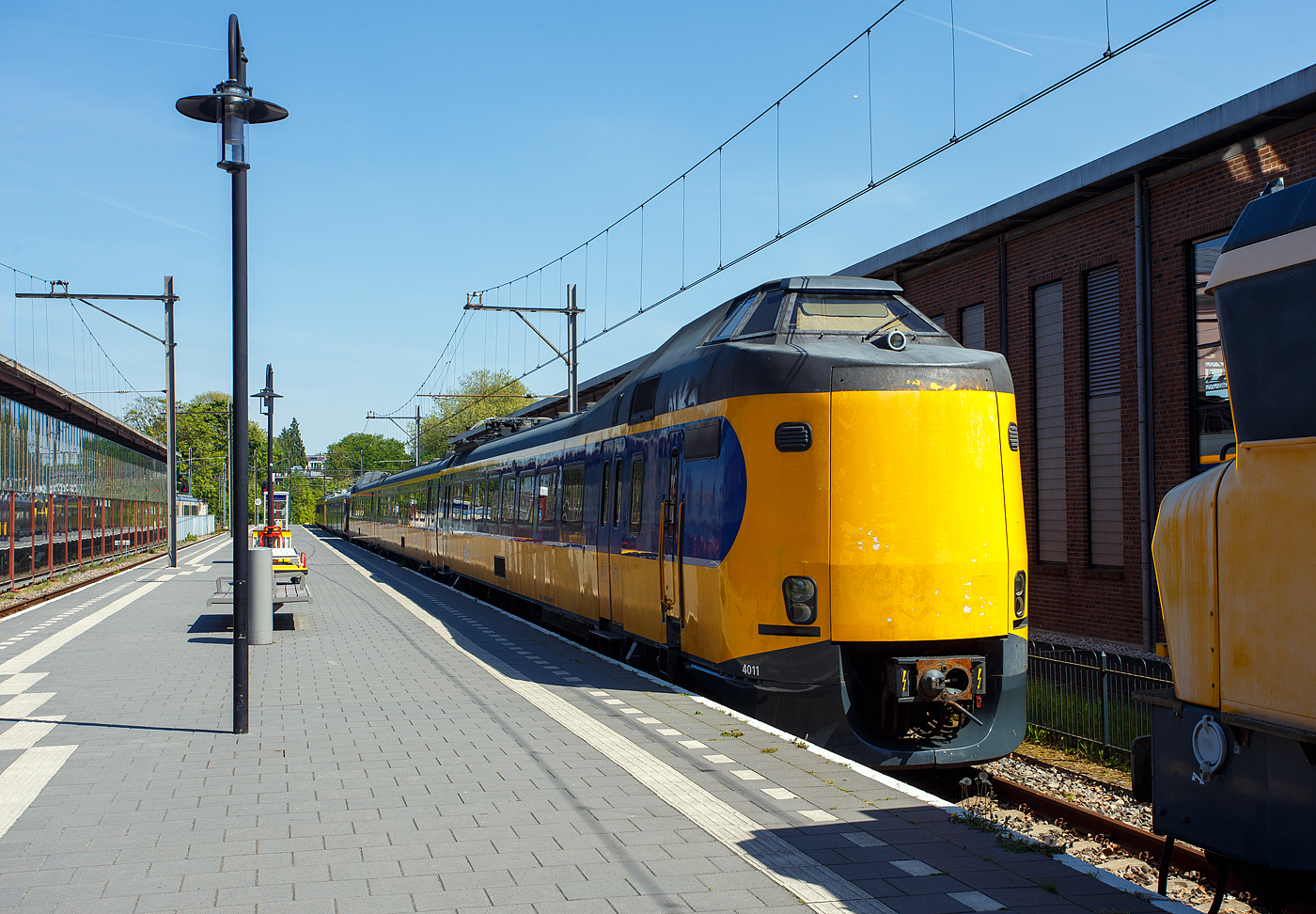 Der NS Koploper ICM 4011 (NL-NS 94 84 4385011-0), ein dreiteilige Elektrotriebwagenzug vom Typ ICM / Plan Z (Koploper), am 29 April 2025 im Het Spoorwegmuseum (bis 2005 NSM - Nederlands Spoorwegmuseum / Niederländischen Eisenbahnmuseum) in Utrecht im Bahnhof Maliebaanstation. Ein sehr schönes Eisenbahnmuseum das zum Verweilen einlädt, leider fehlte uns dieses Mal die Zeit dafür. Übrigens das Gleis 2 (nebenan) ist noch ein aktives Bahngleis, hier fährt stündlich der Pendelzug (als RE) von Utrecht Centraal ein bzw. aus. 

Der Koploper ICM 4011 wurde 1983 von der Waggonfabrik Talbot GmbH & Co. (heute Bombardier) in Aachen (D) für die für die NS - Nederlandse Spoorwegen (Niederländischen Staatsbahnen) gebaut und geliefert. Die Fahrmotoren sind von CEM Oerlikon (Frankreich), und elektrische Installation von Holec (Smit Slikkerveer & Heemaf).

Er war nach den 1977 produzierten sieben Prototypen 1977 (ICM-0), der erste der Serienfertigung (ICM-1). Gegenüber den Prototypen wiesen die Einheiten zahlreiche Verbesserungen (z. B. eine verbesserte Belüftung der Fahrgasträume) auf. Der 4011  Koploper  schied im Mai 2024 aus dem aktiven Dienst bei der NS aus und ging dann ins Museum.

Die ICM (Intercitymaterieel) der NS sind elektrische Triebzüge aus den Jahren 1977 bis 1994 für den Intercity-Verkehr. Mit insgesamt 144 gebauten Einheiten (94 dreiteilige und 50 vierteilige) stellt sie bis heute das Rückgrat des Schnellverkehrs innerhalb der Niederlande dar. 

Volkstümlich werden sie wegen der Wagenübergänge an den Führerstandsenden Koploper (wörtlich «Kopfläufer») genannt. Die Führerstände befinden sich in Panoramakanzeln über dem Übergang, was diesen Wagen ein sehr bulliges Aussehen verleiht. Bis 2005 war es möglich, während der Fahrt von einem Zugteil in den anderen zu wechseln. Die Wagenübergänge an den Endwagen wurden bei der Modernisierung ab 2006 bei allen Zügen entfernt, die beiden Kopftüren wurden durch eine geschlossene Kunststoffplatte (hier gut zuerkennen) ersetzt.

Entwickelt wurden die ICM im Rahmen des «Plans Z» zur Modernisierung des Rollmaterials der NS. Talbot in Aachen produzierte 1977 sieben Prototypen eines dreiteiligen Triebzuges für den schnellen und komfortablen Intercity-Verkehr. Zuerst kamen sie auf der Relation Eindhoven–Venlo zum Einsatz, danach fuhren sie auch zwischen Amsterdam und Nijmegen. Nachträglich erhielten sie die Bezeichnung ICM-0, im Jahr 2003 wurden diese z-gestellt. Die ICM-0 waren noch Wegmann-Drehgestellen ausgestattet.

1983 begann die Serienfertigung des jetzt als ICM-1 bezeichneten Typs. Gegenüber den Prototypen wiesen die Einheiten zahlreiche Verbesserungen auf. Diese erhielten zum Gegensatz der Prototypen nun SIG-Drehgestellen vom Typ GSG 4 (später von RMO Werkspoor in Amsterdam). Ab der Einheit 4051 wurden Choppersteuerungen eingebaut und die Typenbezeichnung änderte sich auf ICM-2. Ab 1990 wurden die ICM als vierteilige Züge (Serien ICM-3 und ICM-4) ausgeliefert, zudem hatte diese nun Magnetschienenbremsen. 

Technik:
Die dreiteiligen Zuggarnituren sind 80,6 m lang und 144 t schwer. Ein Triebzug ist mit 4 Fahrmotoren vom Typ 4 EKO 3250 von TCO - Traction CEM-Oerlikon (Paris, Frankreich) ausgestattet. Später wurden auch Fahrmotoren von Holec vom Typ GT42/30 verbaut. Motor liefert eine Leistung von 315 kW (418 PS) mit
bis zu 2.715 U/min, kurzzeitig ist eine max. Leistung von 344 kW möglich. Insgesamt verfügt ein Triebzug über eine Leistung von 1.260 kW. Die Motoren sind voll gefedert und die Kraftübertragung erfolgt über eine Sécheron-Lamellenkupplung. Der Zug ist für eine Geschwindigkeit von 160 km/h ausgelegt. Der Zug verfügt über 35 Sitzplätze der ersten Klasse und 152 Sitzplätze der zweiten Klasse. Die beiden Kompressoren sind unter dem Fahrgestell untergebracht. Zur Stromversorgung des Steuerstroms und der Beleuchtung dient ein Motorgenerator der unter dem Wagen installiert ist. Dieser wandelt die 1.500 Volt Oberleitungsspannung in 12 Volt Spannung für den Steuerstrom und Beleuchtung um. Der mBDk-Wagen ist mit zwei Stromabnehmern vom Typ AM30 von Faiveley ausgestattet. Um zu verhindern, dass zu viel Strom durch den Zug fließt, sind die Züge mit einem Smit-Schnellschalter ausgestattet. Die Drehgestelle sind SIG - Schweizerische Industrie-Gesellschaft aus Neuhausen am Rheinfall (Schweiz) vom Typ SIG-GSG 4, Triebdrehgestelle haben einen Achsabstand von 2.700 mm und die Laufdrehgestelle von 2.500 mm.

Modernisierung:
Ab November 2006 wurde die Intercity-Ausrüstung der dreiteiligen Züge (Serie 4011–4097) modernisiert. Im April 2007 wurde der erste Triebzug von NedTrain Betriebswerk Haarlem geliefert und in den normalen Regeldienst aufgenommen. Um sie von den noch nicht modernisierten Triebzügen zu unterscheiden, werden die modernisierten Triebzüge als ICMm bezeichnet. Diese Züge wurden komplett saniert und bieten etwa 13 % mehr Sitzplätze. Darüber hinaus unterscheidet sich die erste von der zweiten Klasse klarer: Die erste Klasse hat rote Sitze, die zweite Klasse blaue, wie bei anderen modernisierten Fahrzeugen und neu gebauten Fahrzeugen aus dem Jahr 2006. Darüber hinaus sind die ICMm mit zusätzlichen Einrichtungen wie einer Rollstuhl-Toilette, einer Klimaanlage, Fahrgast-Informations-Displays, einer digitalen Zugzielanzeige und einem statischen Wandler anstelle des bisherigen Motorgenerators ausgestattet. Die Modernisierung der dreiteiligen Triebzüge kostete 190 Millionen Euro.

Die Wagenübergänge an den Endwagen wurden bei dieser Revision bei allen Zügen entfernt. Das Gesamtgewicht eines Triebzuges verringert sich um etwa 1.000 kg (1 t), wenn beide Wagenübergänge durch Kunststoffabdeckplatten ersetzt wurden. Dies wirkt sich positiv auf den Energieverbrauch aus.

Dass die Anzahl der Toiletten halbiert wurde, stieß auf Kritik, auf die die NS aber nicht reagierte.

Der Triebzug 4011 war der erste, der im November 2006 modernisiert wurde und am 16. April 2007 nach Tests in der Klimakammer in Wien sowie einer Reihe von Testfahrten, Kontrollen und Anweisungen an das Personal in Betrieb genommen wurde. Am ersten Betriebstag wurde diese Einheit auf der Intercity-Linie 1500 (Amsterdam – Amersfoort – Deventer) eingesetzt. Der Umbau der dreiteiligen Koplopers (der Serie 40xx) dauerte bis zum 2. Quartal 2010. Der Triebzug 4205 war als erster vierteiliger Triebzug am 22. Februar 2009 in der Werkstatt von Haarlem zur Modernisierung und ging Anfang Januar wieder in Betrieb. Im Februar 2010 wurde mit dem Serienumbau der vierteiligen Triebzüge begonnen. Der letzte ICMm (4240) wurde am 6. Oktober 2011 ausgeliefert.

TECHNISCHE DATEN:
Gebaute Anzahl: 144 (davon 94 dreiteilige ET und 50 vierteilige ET)
Hersteller:Talbot in Aachen (mech. Teil), Oerlikon, Holec (elektr. Ausrüstung)
Baujahre: ab 1977
Spurweite: 	1.435 mm
Achsfolge: Bo'Bo'+2'2'+2'2' (12 Achsen)	 / Bo'Bo'+Bo'2'+2'2'+2'2' (16 Achsen)
Länge über Kupplung: 80.600 mm / 107.100 mm
Achsabstand im Triebdrehgestell: 2.700 mm
Achsabstand im Laufdrehgestell: 2.500 mm
Treibraddurchmesser: 950 mm (neu)
Laufraddurchmesser: 920 mm (neu)
Leergewicht: 144 t / 192 t	
Höchstgeschwindigkeit: 160 km/h 
Motorentyp: 4 bzw. 6 Stück vom Typ 4 EKO 3250 mit je 315 kW (418 PS)
Leistung: 1.260 kW / 1890 kW 
Stromsystem: 1,5 kV Gleichstrom
Kupplung: Scharfenberg
