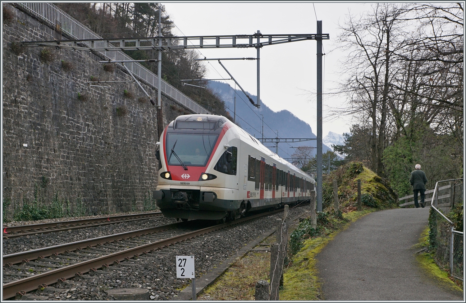 Der SBB RABe 523 059 (und ein weitere) auf dem Weg in Richtung Lausanne bei Kilometer 27.2; hinter den Bäumen  versteckt  sich das Schloss Chillon.

21. Feb. 2024  