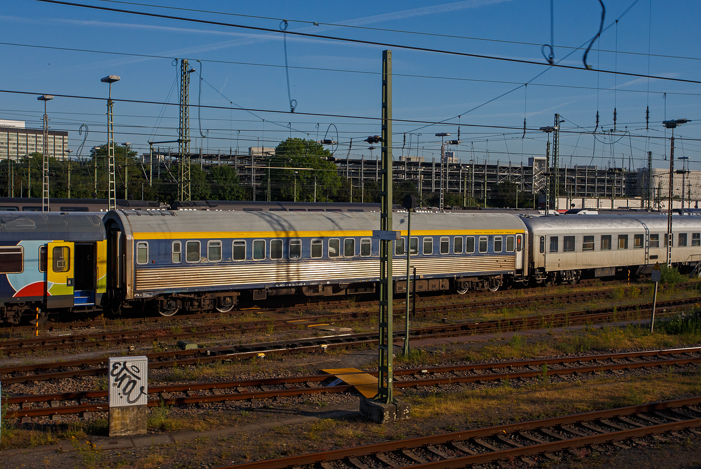 Der Schlafwagen der Gattung WLAB (ex CIWL 4536, Typ WL AB30, ex WL P), NL-MSM 61 84 06-70 418-8, der MSM Gruppe Inh. Niko Maedge e.K. (Köln) abgestellt am 20 Mai 2025 im Zugverband in Köln-Deutzerfeld, aus einem Zug heraus fotografiert, leider mit einem Mast davor.

Der Wagen wurde 1955 von der französischen Firma Etablissements Carel Fouché & Cie. (Le Mans) gebaut und als CIWL 4536 an die Compagnie Internationale des Wagons-Lits (CIWL), seit 1967 Compagnie Internationale des Wagons-Lits et du Tourisme (CIWLT, deutsch Internationale Schlafwagen- und Touristik-Gesellschaft), geliefert. Die CIWL/CIWLT ist das älteste europäische Unternehmen zum Betrieb von Schlafwagen, Speisewagen und Luxuszügen.

Der Wagen hatte folgende Bezeichnungen:
Ab 1955 - CIWL 4536 (Typ WL AB30, ex WL P)
CIWLT 51 66 06-50 036-6
SNCF 61 87 75-41 726-3
Ab 1992 - NS 71 84 70-70 018-5
NS 61 84 70-70 418-9
Ab 2004 - NL- EETC 61 84 70-70 418-9
Ab 2006 - NL- EETC 61 84 06-70 418-8
Ab 2016 - NL-MSM 61 84 06-70 418-8 (vermutlich 1922 verkauft an Train Rental GmbH (TC) 

Der Wagenursprung:
Der Typ P der Compagnie Internationale des Wagon-Lits (CIWL) war eine Schlafwagen-Type mit Außenhaut aus blankem Edelstahl. Sie wurden in Lizenz von Budd nach amerikanischem Vorbild hergestellt. Das an die französischen INOX-Wagen erinnernde Aussehen in blankem Metall blieb beim sonst von der Farbe Blau dominierten Fahrzeugpark der CIWL einzigartig.

Insgesamt 80 Wagen wurden 1955 von den Unternehmen Le Brugeoise et Nivelles, Ansaldo, Carel & Fouché sowie Fiat Ferroviaria gebaut. Sie erhielten die laufenden Nummern 4501 bis 4580. Die Wagen besaßen 20 ineinander verschachtelte Einzelabteile der „Spezial-Klasse“ nach Vorbild der amerikanischen „Double-Roomettes“, wobei die Frequenz dieser in Europa unbekannten Einzelabteile von Beginn an sehr zu wünschen übrigließ. Um 1970 wurden die Wagen von Faltenbalg- auf Gummiwulst-Übergänge umgebaut.

Nach der Übernahme des CIWL-Fuhrparks in den Besitz der jeweiligen Staatsbahnen bzw. durch Trans-Euro-Nacht wurden in den Jahren 1992 bis 1994 im RSI-Werk Ostende 20 Fahrzeuge für die ÖBB, die Nederlandse Spoorwegen sowie die Belgischen Staatsbahnen umfassend umgebaut. Dabei entstanden aus 20 Einbettabteilen 10 geräumige Dreibettabteile mit Waschbecken, Tisch und Sessel; die relativ engen Toilettenräume und das Dienstabteil am Ende ohne Einstieg blieben bestehen. Die Klimaanlagen wurden erneuert. Die Wagen erhielten Schlingerdämpfern, sowie neue Drehgestelle (Schlieren-Drehgestelle Typ 27 anstelle der Schlieren Typ N), so wurde die Höchstgeschwindigkeit auf 160 km/h gesteigert. Das Innenraumdesign wurde in Pastelltönen und die Farbgebung mit kobaltblauem Fensterband und gelbem Begleitstreifen darüber wurde neugestaltet. Die Kosten für die Renovierung beliefen sich auf 1,7 Millionen Gulden (heute ca. 765.000 Euro) pro Waggon.

Die NS und SNCB betrieben je fünf Wagen bis 2003 und beendeten dann beide den Betrieb eigener Schlaf- und Liegewagen. Die NS-Wagen gingen zunächst an Euro-Express Treincharter, die SNCB-Wagen an TTC, beide Unternehmen setzten sie in saisonalen Urlaubszügen ein. Die ÖBB schieden die letzten Wagen im Jahr 2017 aus.

Heute (2023) werden die verbleibenden Wagen bei TRI Train Rental, Euro-Express Sonderzüge und der MSM-Gruppe in Urlaubszügen eingesetzt (teilweise als Ersatzteilspender). 

TECHNISCHE DATEN (nach Umbau):
Gebaute Anzahl: 80
Baujahre: ab 1955
Spurweite: 1.435 mm (Normalspur)
Länge über Puffer: 24.050 mm
Länge Wagenkasten: 22.748 mm
Drehzapfenabstand: 16.500 mm
Drehgestelltype: Schlieren 27 (zuvor Schlieren N)
Breite: 2.865 mm
Höhe über SOK: 4.248 mm
Leergewicht: 48,5 t
Höchstgeschwindigkeit: 160 km/h
Abteile: 10 (für 1, 2 oder 3 Passagiere)
Dienstabteil: 1
Toiletten: 2