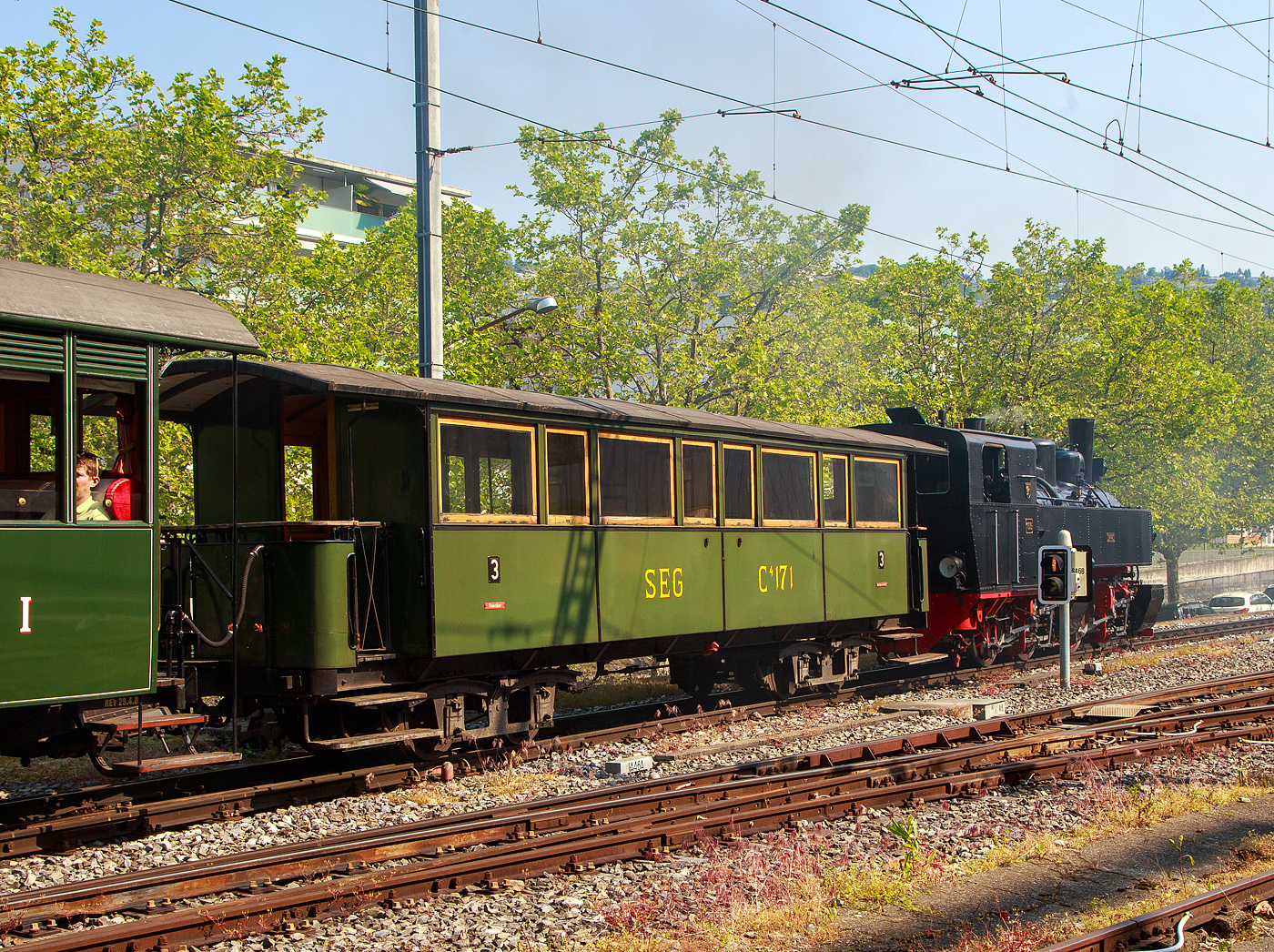 Der sehr schöne meterspurige vierachsige 3. Klasse (Raucher / Nichtraucher) Drehgestell-Großraum-Plattformwagen SEG C⁴ 171 der Museumsbahn Blonay-Chamby, ein ehemaliger Wagen Süddeutsche Eisenbahn-Gesellschaft, am 28.05.2023 im Zugverband in Vevey, dahinter die Mallet-Dampflok G 2x2/2 105  Todtnau , ex SEG 105  Todtnau .

Der Wagen wurde 1891 von der Waggonfabrik P. Herbrand & Cie. in Köln-Ehrenfeld gebaut und an die Süddeutschen Eisenbahn-Gesellschaft (SEG) geliefert, 1950 wurde der Wagen modernisiert. Am 1. Januar 1953 übernahm das Land Baden-Württemberg alle drei Betriebe und brachte sie zum 1. Oktober 1953 als Auffanggesellschaft in die Mittelbadische Eisenbahnen AG ein. Dazu gehörte u.a. die schmalspurige Zell-Todtnauer-Eisenbahn. Die Stilllegung der Zell-Todtnauer Eisenbahn für den Personenverkehr erfolgte am 25. September 1966 sowie für den Güterverkehr am 24. September 1967. Seit 1967 ist der Wagen bei der Museumsbahn BC, die Form der Beschriftung ist unhistorisch.

TECHNISCHE DATEN:
Baujahr: 1891
Hersteller: Waggonfabrik P. Herbrand & Cie. in Köln-Ehrenfeld
Spurweite: 1.000 mm (Meterspur)
Achsanzahl: 4
Länge über Puffer: 11.300 mm
Länge Wagenkasten: 10.600 mm (mit Plattformen)
Drehzapfenabstand: 6.000 mm
Achsabstand im Drehgestell: 1.200 mm
Eigengewicht: 10,0 t
Sitzplätze: 46 in der 3. Klasse