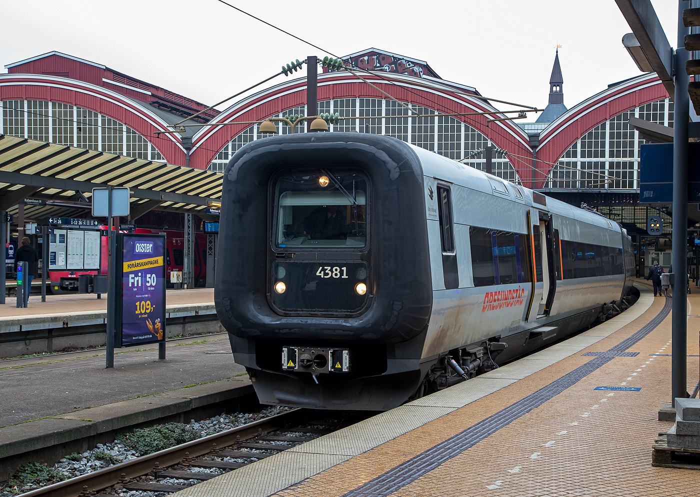 Der Transitio X31K 4381 (M4381, T4781 und M4581, bei DSB ET-FT-ET), ein ADtrnaz/Bombardier Crusalis Contessa, verlsst am 20 Mrz 2019 als resundstog (schwedisch resundstg) den Hauptbahnhof Kopenhagen (Kbenhavns Hovedbanegrd). 

Der dreiteilige Elektrotriebzug wurde 2008 von Bombardier gebaut und an die dnische DSB als ET-FT-ET 4381 geliefert, 2011 ging er an die schwedische AB Transitio. Die heutigen UIC-Nummern sind 94 74 4314 381-5 S-ABTR / 94 74 4314 781-6 S-ABTR / 94 74 4314 581-0 S-ABTR.

Der SJ X31K ist ein schwedischer dreiteiliger Elektrotriebzug der von Adtranz (spter Bombardier), als Crusalis Contessa fr die SJ (Statens Jrnvgar) gebaut wurde. In Dnemark hat der Zug die Baureihenbezeichnung ET. Der Kennbuchstabe K bedeutet, dass die Triebzge fr den Verkehr nach und in Dnemark angepasst sind, d.h. es sind Zweisystem-Triebzge die in Schweden (15 kV 16⅔ Hz) und Dnemark (25 kV 50 Hz) unterschiedlichen elektrischen Systeme. Beide Lnder haben unterschiedliche Zugbeeinflussungseinrichtungen und Signalsysteme. Die Umschaltung zwischen den beiden Systemen erfolgt whrend der Fahrt auf Peberholm. 

Die Triebzge werden hauptschlich im resundstg-Verkehr in der Relation der Stdte Helsingr–Kopenhagen–Malm und darber hinaus nach ngelholm, Gteborg, Hssleholm, Kalmar und Karlskrona eingesetzt. Die X31 verkehren auch als InterCity-Zug auf der Vstkustbana unter der Regie von Statens Jrnvgar (SJ). Etwa die Hlfte der Zge gehrt den Danske Statsbaner (DSB) und werden unter der dnischen Baureihenbezeichnung ET gefhrt, den Rest betreiben verschiedene schwedische Betreiber fr die Gesellschaft resund AB.

Die Triebzge sind rund 79 Meter lang und haben ein Leergewicht von etwa 156 Tonnen. Jeder Zug besteht aus zwei angetriebenen End- sowie einem antriebslosen Mittelwagen, der die Stromabnehmer und die Hochspannungsdachausrstung trgt und verfgt ber insgesamt 229 Sitzpltze, davon 20 Sitzpltze in der 1. Klasse sowie 31 Klappsitze. In dem Dreiwagenzug trgt jeder Wagen eine eigene Nummer, wobei die Endziffern bereinstimmen: 43xxhat einen Fhrerstand, 47xx ist der Mittelwagen und 45xx hat einen Fhrerstand und ein Erste-Klasse-Abteil.

Die Wagenksten haben eine Breite von 2,97 m und wurden aus wartungsfreiem Edelstahl gefertigt. Sie besitzen eine hellgraue Farbgebung, um optisch zu den dnischen Triebwagen aus Aluminium zu passen. Die Frontseiten sind durch die breiten Gummiwlste schwarz. Bis zu fnf Einheiten knnen miteinander gekuppelt und in Mehrfachtraktion gefahren werden. Die Fronttren mit Fhrerstand knnen seitlich weggeschwenkt werden, damit besteht freier Durchgang durch den gesamten Zug. Dies ist eine Sicherheitsanforderung bei der Fahrt durch den Drogdentunnel als Teil der resundverbindung. Weitere Sicherheitsanforderungen sind die Notbremsberbrckung, eine Grundvoraussetzung fr Zge auf der resundverbindung und im Citytunnel Malm. Auf der resundverbindung ist nicht wie sonst in Schweden der Triebfahrzeugfhrer fr die Sicherheit der Passagiere verantwortlich, ohne Bordpersonal gelten die dnischen Vorschriften.

Der elektrische Triebzug speist beim regenerativen Bremsen wieder Strom in die Oberleitung ein. Die Hchstgeschwindigkeit liegt bei 180 km/h. Acht der zwlf Achsen eines Triebzuges sind mit Asynchronmotoren angetrieben, was bei einer maximalen Leistung von 2.300 kW zu guten Beschleunigungswerten fhrt. Der Mittelwagen luft auf zwei Laufdrehgestellen.Die Triebgestelle weisen einen Achsstand von 2.600 mm und sind mit zwei Fahrmotoren ausgestattet. An den Radscheiben der Triebdrehgestelle sind die Bremsscheiben der Scheibenbremsen angebracht. Drei der vier Triebdrehgestelle besitzen zudem eine Magnetschienenbremse.

TECHNISCHE DATEN:
Spurweite:  1.435 mm (Normalspur)
Achsformel: Bo’Bo’+2’2’+Bo’Bo’
Lnge ber Kupplung: 78.900 mm 
Hhe: 3.800 mm
Breite: 2.966 mm
Eigengewicht: 156 t 
Hchstgeschwindigkeit: 180 km/h
Dauerleistung: 2.300 kW  (8 x 287,5)
Anfahrzugkraft: 170 kN
Anzahl der Fahrmotoren:8
Stromsystem: 25 kV 50 Hz und 15 kV 16⅔ Hz
Sitzpltze:  20 (1. Klasse) / 178 (2. Klasse) und 31 Klappsitze
Kupplungstyp: Scharfenbergkupplung