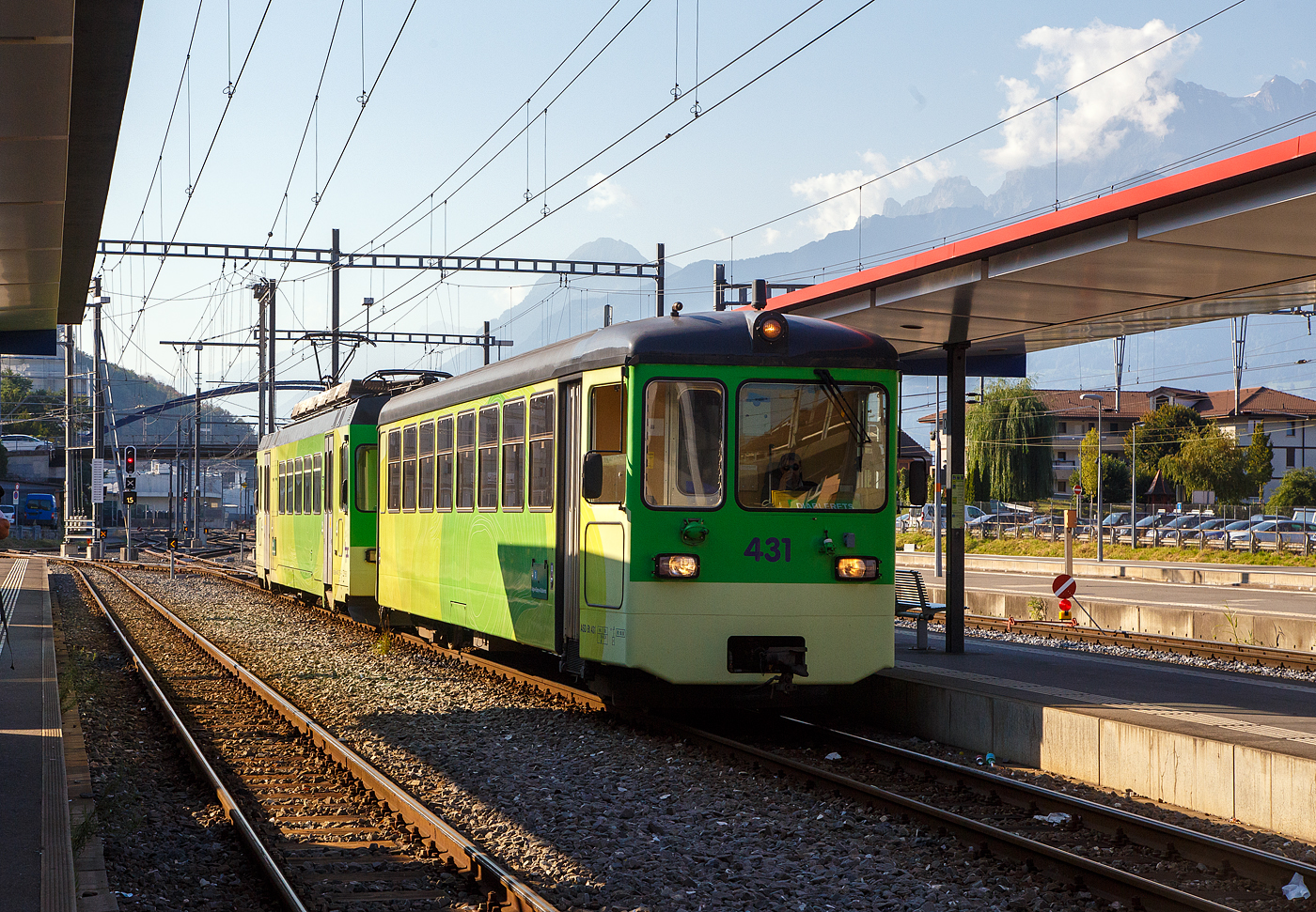 Der Triebwagen tpc ASD BDe 4/4 403 „Ollon” mit dem Steuerwagen tpc ASD Bt 431 erreicht am 10 September 2023 Steuerwagen voraus, als ASD (Aigle–Sépey–Diablerets) Regionalzug R 24 von Les Diablerets via Le Sépey, nun den Bahnhof Aigle. Die 23,3 Kilometer lange Strecke der ASD (Aigle–Sépey–Diablerets) ist eine reine Adhäsionsbahn und führt von Aigle über Le Sépey nach Les Diablerets.

Der elektrische Personen-Triebwagen mit Gepäckabteil wurde 1987 von Vevey ACMV (Ateliers de constructions mécaniques de Vevey) in Vevey gebaut, die elektrische
 Ausrüstung ist von der BBC (Brown, Boveri & Cie.). Er ist ein sogenannter ACMV Westschweizer Meterspurtriebwagen der zweiten Generation. 

Die Westschweizer Meterspurtriebwagen sind elektrische Triebwagen, die 1985 bis 1992 von den Ateliers de constructions mécaniques de Vevey ACMV und 1996 von Vevey Technologies an sechs Westschweizer Privatbahnen für verschiedene Stromsysteme und zum Teil mit gemischtem Adhäsions- und Zahnradantrieb geliefert wurden. Die Fahrzeugfamilie ist modular aufgebaut und ließ sich bezüglich ihrer Größe und Ausstattung an die Erfordernisse der jeweiligen Bahngesellschaft anpassen. Die Triebwagen wurden elf Jahre produziert und während dieser Zeit der technischen Entwicklung angepasst.

Die Fahrzeuge sind in leichter Stahlbauart konstruiert und 2,65 Meter breit. Die Schürzen, der Unterteil des Kastens, wurden aus Aluminium-Stangpressprofilen hergestellt, die nach einer Kollision mit Kraftfahrzeugen ausgewechselt werden können. An den Stirnwänden wurden bei weniger beanspruchten Elementen Formteile aus glasfaserverstärktem Kunststoff verwendet. Die Wagenkästen der Triebwagen sind für die Aufnahme der elektrischen Ausrüstung verstärkt und mit Befestigungspunkten versehen. Für die Laufdrehgestelle wurde eine Bauart übernommen, die schon bei Steuerwagen der Chemin de fer Bière–Apples–Morges und Chemin de fer Yverdon–Ste-Croix verwendet wurde. Die Triebdrehgestelle verfügen über einen Rolldrehkranz und zwei längs angeordnete Fahrmotoren, die je eine Achse über Kardanwellen antreiben.

Neben einer Rekuperations- und einer Widerstandsbremse sind die Triebwagen mit einer selbsttätigen Druckluftbremse ausgerüstet. Weil deren Hauptleitung durch die Elektronik gesteuert wird, kann der Zug einhändig mit dem Fahrschalter bedient werden.

Die Aigle–Sépey–Diablerets-Bahn (ASD), seit 1999 Teil der Transports Publics du Chablais (TPC), konnten 1987 neues Rollmaterial beschaffen, so auch vier dieser Triebwagen BDe 4/4 (401 bis 404). Wegen ihrer engen Kurven dienten die kurzen NStCM-Triebwagen als Basisfahrzeug. Als Steuerwagen dienen der ASD Fahrzeuge der ehemaligen Birsigthalbahn, die sie von der Baselland Transport (BLT) erworben werden konnte. Für den Einsatz auf der ASD wurde der Führerstand, bei den ex BTB-Steuerwagen neu aufgebaut.

Auch die AOMC (Aigle-Ollon-Monthey-Champéry-Bahn) hat drei solcher Triebwagen (BDeh 4/4 501 bis 503) beschafft, diese waren aber durch den Zahnradbetrieb und das andere Stromsystem der AOMC doch anders ausgeführt, u.a. auch in besonderer Leichtbauweise. Um die technischen Normalien ihrer Strecken zu vereinheitlichen, bauten die TPC im Jahr 2016 die Linie von Aigle nach Champéry um. Sie ersetzten das bisherige Zahnstangensystem Strub durch eine Abt-Zahnstange und erhöhten die Fahrleitungsspannung auf 1500 Volt. Damit verloren diese BDeh 4/4 501–503 und die zugehörigen Steuerwagen ihr Einsatzgebiet.

TECHNISCHE DATEN:
Baujahr: 1987 (4 Stück)
Spurweite:	1.000 mm
Achsformel: Bo’Bo’
Wagenkastenmaterial: Stahl
Länge über Puffer:18.800 mm
Breite: 2.650 mm
Gewicht: 32,4 t
Höchstgeschwindigkeit: 65 km/h (ursprünglich 25 km/h)
Leistung: 820 kW
Stromsystem: 1500 Volt DC (Gleichstrom)
Elektrische Ausrüstung: Schützensteuerung
Sitzplätze: 32
Kupplungstyp: BSi -Kompaktkupplung 

Die BSI-Kompaktkupplung ist eine mechanische Vorrichtung zum Verbinden zweier Schienenfahrzeuge zu einem Zug. Sie überträgt die Zug- und Druckkräfte innerhalb eines Zugverbandes und lässt sich automatisch kuppeln und entkuppeln. Sie findet überwiegend bei Straßenbahnwagen und Regionaltriebwagen der Eisenbahn Verwendung. Die Kupplung wurde vom ehemaligen Unternehmen Bergische Stahl-Industrie-Gesellschaft in Remscheid entwickelt, inzwischen Teil der Wabtec-Gruppe.


Der Steuerwagen tpc ASD Bt 431,  ex BTB/BLT (Bt 26):
Die Geschichte:
Anlässlich der Modernisierung des BTB-Rollmaterials und für die Bildung von die Betriebsabwicklung stark vereinfachenden Pendelzügen wurden 1966 auch sieben Steuerwagen Bt 21 bis 27 beschafft. Diese standen jedoch lediglich sechs neuen Triebwagen ABe 4/4 11 bis 16 gegenüber. Der zusätzliche Steuerwagen wurde ab 1977 für einen Pendelzug mit den entsprechend angepassten Be 4/4 der Serie 8 bis 9 aus dem Jahre 1951 benötigt.

Die Steuerwagen entsprachen bezüglich des wagenbaulichen Teils so weit als möglich den Motorwagen. Es waren zwei Fahrgastabteile (Raucher/Nichtraucher) vorhanden. Auf der führerstandslosen Seite befanden sich die Plattformen mit den beidseitigen, pneumatisch betätigten Falttüren ganz am Wagenende, um im Wageninnern möglichst viele Sitzplätze anordnen zu können. Als Drehgestelle kamen solche elastischer Bauart mit Flexicoil-Lagerung und Gummi-Zusatzfedern sowie Klotzbremse zum Einbau.

Der Führerstand entsprach jenem der Motorwagen (ABe 4/4). Er war von Anfang an so ausgelegt, dass auch die entsprechend angepassten Be 4/4 8 und 9 ferngesteuert werden konnten. Eine Stirnwandtüre ermöglichte das Mitführen von Zusatzwagen oder das Einreihen eines Steuerwagens in der Zugsmitte. 1972 wurde der Zugfunk nachgerüstet.

Mit der Fusion der Basler Vorortsbahnen 1974 gingen alle sieben Steuerwagen, welche immer Seite Rodersdorf an die Züge gestellt wurden, an die neugegründete Baselland Transport AG (BLT) über ,so wurde dieser zum BLT Bt 26.

Nach der Betriebsumstellung im Herbst 1984 verkaufte die BLT alle sieben Fahrzeuge in die Westschweiz. Die Bt 22, 23, 24 und 25 kamen als Bt 132, 133, 134 und 131 zur Schmalspurbahn Aigle–Ollon–Monthey–Champéry (AOMC).

Die Bt 21 sowie 26 und 27 fanden den Weg zur Aigle–Sépey–Diablerets-Bahn (ASD). Ab September 1985 wurden sie bei ACMV in Vevey für den Betrieb mit den für 1987 bestellten Triebwagen BDe 4/4 401 bis 404 hergerichtet. Die Anpassungen umfassten im Wesentlichen:
• Neuanstrich
• Verschließen der vorderen Stirnwandtüren
• Einbau eines neuen Führertisches
• Anpassungen an den Steuerstromkreisen
• Anpassungen der elektrischen, pneumatischen und mechanischen Kupplungen (BSi)
• Einbau von Schienenbremsmagneten in beide Drehgestelle

Die Inbetriebsetzung erfolgte ab Juni 1987 als Bt 431 bis 433.

TECHNISCCHE DATEN bei Inbetriebsetzung (1966):
Spurweite: 1.000 mm
Typenbezeichnung: Bt
Anzahl Wagen: 7
Länge über alles: 17.212 mm
Größte Breite: 2.500 mm
Höhe über Dach: 3.450 mm
Drehzapfenabstand: 11.000 mm
Achsabstand im Drehgestell: 1.800 mm
Eigengewicht: 17.000 kg
Sitz-/Stehplätze: 64 / 66 (zusätzlich 2 Klappsitze)
Höchstgeschwindigkeit: 65 km/h
Anschaffungskosten/Wg.: CHF 356.205,–

Abweichende heutige Daten:
Eigengewicht: 18 t 
Sitz-/Stehplätze: 56/ 60 
Max. Ladegewicht: 2,5 t (so müsste er eigentlich BDt 431 heißen)

Als vierter Steuerwagen stieß 2000 der jahrelang abgestellte und nie in Betrieb genommene Bt 131 der AOMC (ex BTB/BLT Bt 25) hinzu. Dieses Fahrzeug erfuhr dieselben Anpassungen wie die Bt 431 bis 433,  wobei jedoch in Abweichung dazu die Stirnwandtüre belassen wurde.
