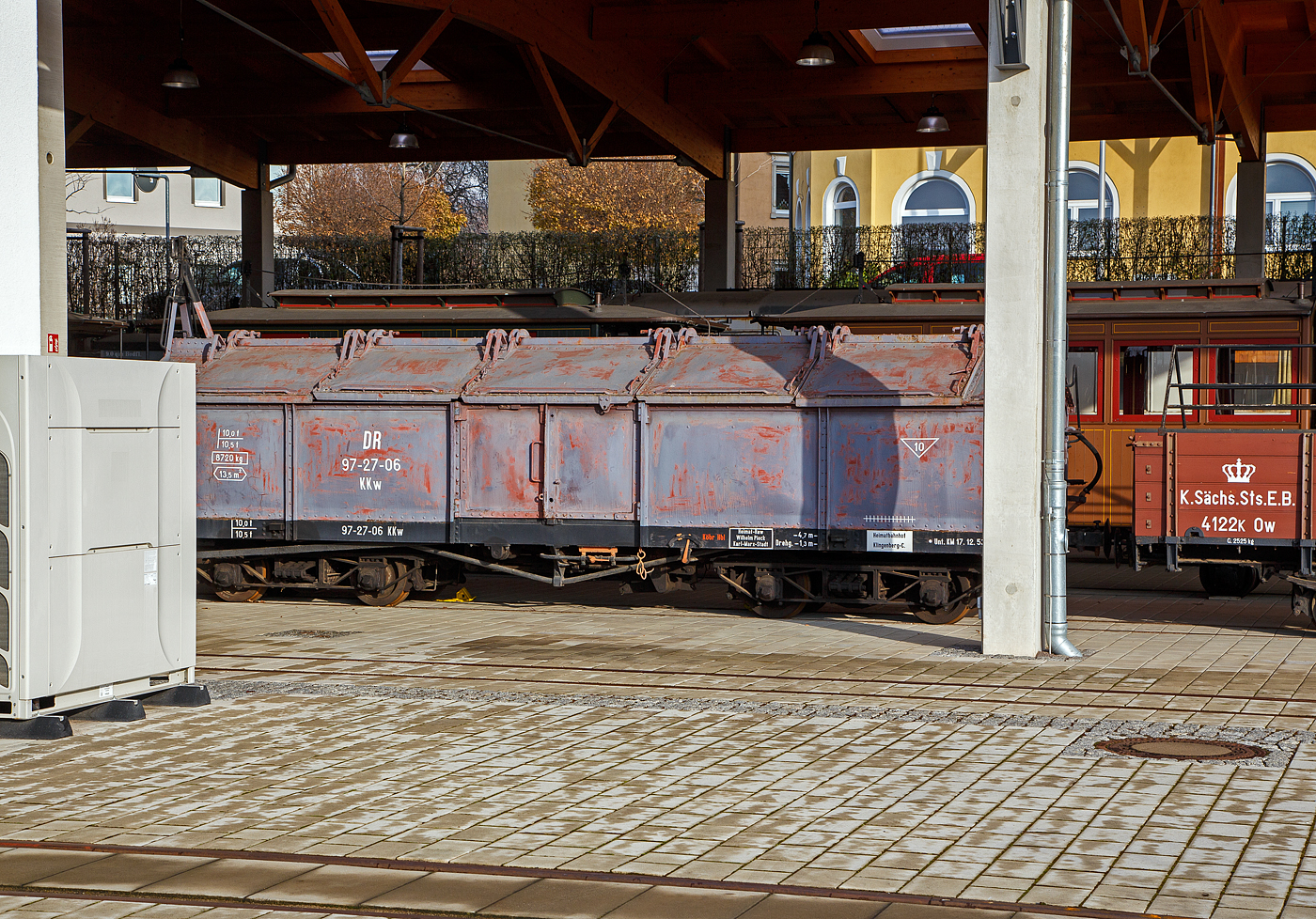 Der vierachsige 750 mm-Schmalspur Gterwagen (Klappdeckelwagen) mit Heberlein-Bremse, ex DR 97-27-06 KKw (Gattung KKw) am 07.12.2022 im Schmalspurbahnmuseum Radebeul der Stiftung Schsische Schmalspurbahnen (SSB) im ehem. Gterboden, durch den Zaun fotografiert, das Museum ist z.Z. leider nicht geffnet, daher auch leider verdeckt.

Der Wagen wurde 1930 vom Waggonfabrik Weimar AG gebaut, und war einst auf der Strecke Klingenberg-Comnitz-Frauenstein eingesetzt. Er ist heute im Bestand des Verkehrsmuseums Dresden.

TECHNISCHE DATEN:
Spurweite: 750 mm
Anzahl der Achsen: 4 (in 2 Drehgestellen)
Drehzapfenabstand: 4.700 mm
Achsabstand im Drehgestell: 1.300 mm
Ladelnge: 8.000 mm
Leergewicht: 8.720 kg
Ladegewicht: 10.000 kg (Tragfhigkeit 10,5 t)
Ladeflche: 13,5 m

