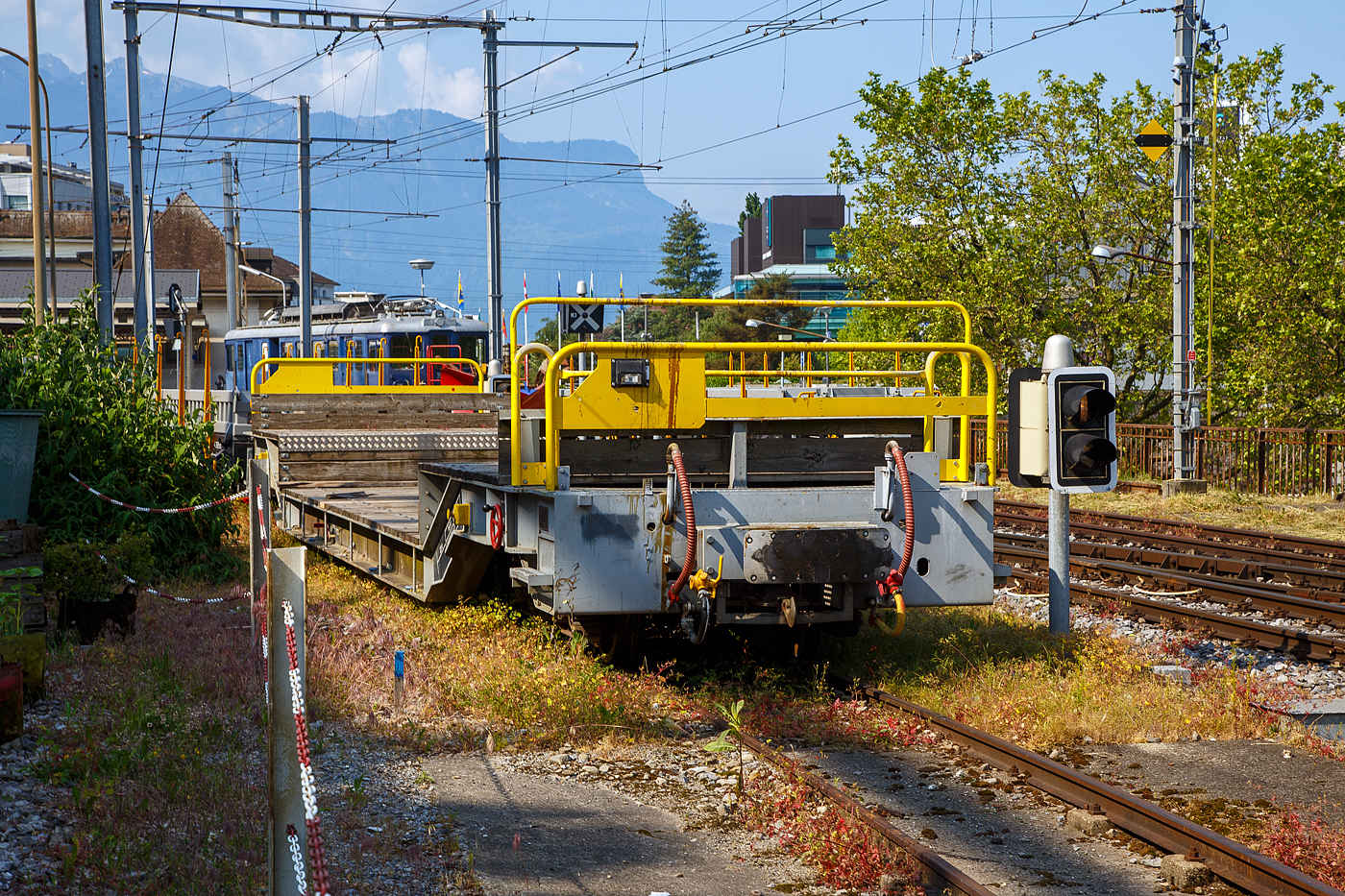 Der vierachsige Drehgestell-Tiefbett-Flachwagen als Dienstgüterwagen MOB X 775 der Montreux-Berner Oberland-Bahn, ex RhB Sbk-v 7705, abgestellt am 28.05.2023 in Vevey.

Der Wagen wurde 1999 von der Josef Meyer Waggon AG in Rheinfelden (CH) unter der Fabriknummer 2314 gebaut und an die RhB (Rhätische Bahn AG - Bündner Güterbahn) als Niederflur-Containerwagen Sbk-v 7705 (RhB Serie Sbk-v 7701-7715) geliefert. Im Februar 2013 wurde der Wagen bei der RhB ausrangiert und an die MOB verkauft. Bei der MOB wurde der Wagen umgebaut und an die MOB Normalien angepasst. Zum Umbau gehörte die komplette Belegung des Stahlrahmens mit Holzbohlen, so wurde aus dem Containerwagen ein Tiefbettflachwagen, das Eigengewicht stieg von 14,2 t auf nun 15,6 t. Im Juni 2013 erfolgte die Inbetriebnahme als X 775 bei der MOB.

1999 bzw. 2002 stellt die RhB vierachsige Drehgestelltragwagen Sbk-v 7701-7715 (26 t Traglast) und Sb-v 7716-7730 (verstärkt, mit 30 t Traglast) in Dienst. Bedingt durch den Niederfluranteil kann zwar nur ein Container transportiert werden, dies allerdings auch auf dem eingeschränkten Lichtraumprofil der Berninabahn.

Sechs dieser Wagen Niederflur-Containerwagen der  RhB Serie Sbk-v 7701-7715 (Sbk-v 7701 bis 7706) wurden von der MOB gekauft und zu den Tiefbett-Flachwagen MOB X 771 bis 776 umgebaut.

TECHNISCHE DATEN:
Hersteller: Josef Meyer Waggon AG in Rheinfelden (CH)
Baujahr: 1999 (Umbau 2013 durch MOB)
Spurweite: 1.000 mm (Meterspur)
Achsanzahl: 4 (in 2 Drehgestellen)
Länge über Puffer: 16.300 mm 
Breite: 2.660 mm
Drehzapfenabstand: 10.370 mm 
Achsabstand im Drehgestellt: 1.400 mm
Laufraddurchmesser: 750 mm
Drehgestell- Typ (Bauart): JMR Or 92/12
Ladelänge im Tiefbett: ca. 7.800 mm
Höhe Tiefbett  ab Schienenoberkante: ca. 600 mm
Eigengewicht: 15.600 kg (ursprünglich bei RhB 14.200 kg)
Max. Ladegewicht: 23 t
Höchstgeschwindigkeit: 90 km/h (>7 t Beladung) / 80 km/h (ab 7 t Beladung)
Feststellbremse: Ja
Kupplungen: Mittelpuffer mit einer Schraubenkupplungen (Zp 1)

Quellen: x-rail.ch, RhB - Bündner Güterbahn und eigene Sichtung