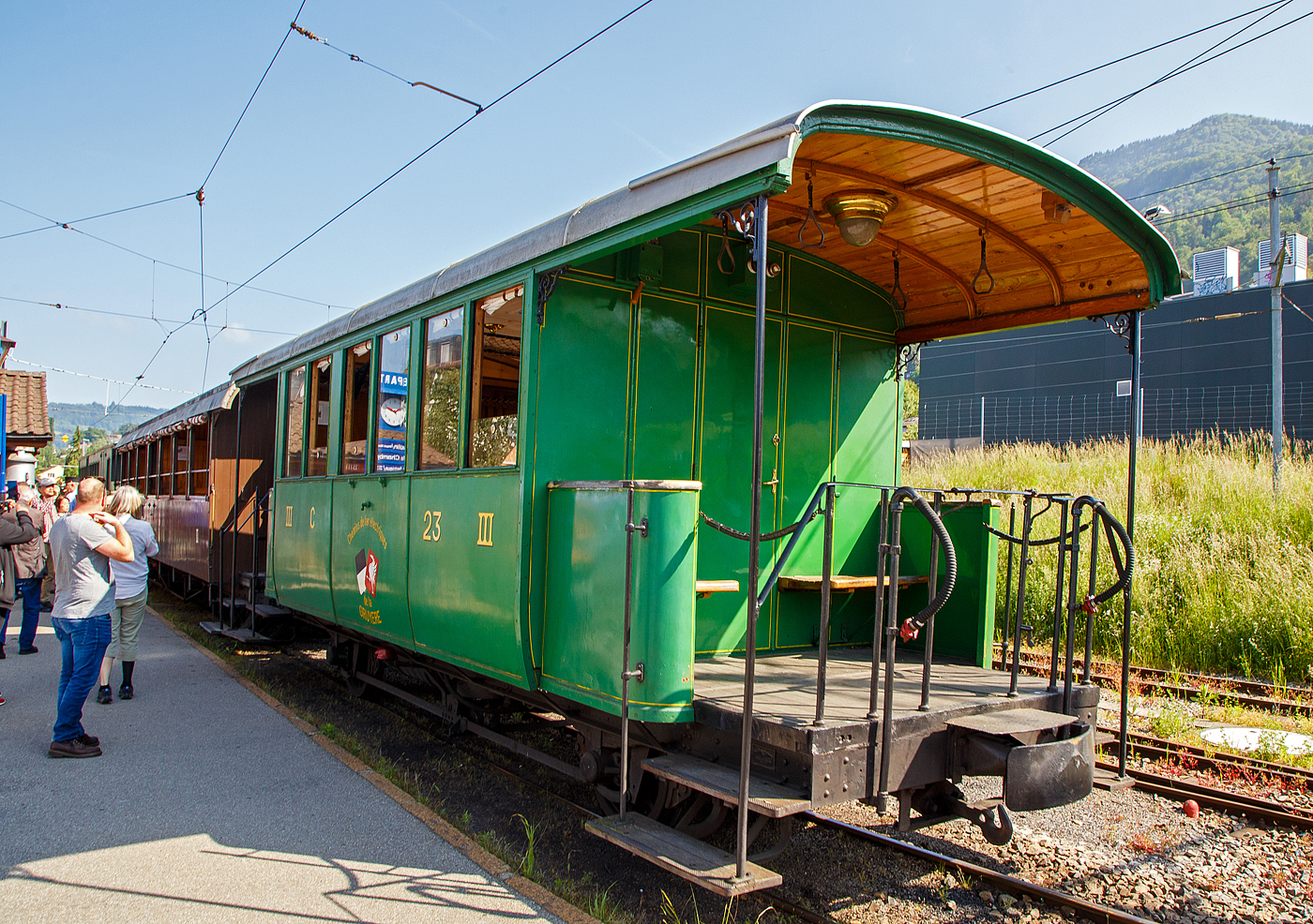 Der zweiachsige 3. Klasse Personenwagen mit offenen Plattformen (Plattformwagen) ex CEG C 23 (Chemins de fer Electriques de la Gruyère, ab 1942 GFM - Chemins de fer fribourgeois Gruyère–Fribourg–Morat) der Museumsbahn Blonay-Chamby am 27.05.2023 im Zugverband im Bahnhof Blonay.

Der Wagen wurde 1903 von der SWS (Schweizerische Wagons- und Aufzügefabrik AG, Schlieren) für die Chemins de fer électriques Veveysans (CEG) gebaut und als CEG C² 23 geliefert. Im Jahr 1967 ging der Wagen an die Museumsbahn Blonay-Chamby.

Die Chemins de fer électriques de la Gruyère schloss sich 1942 mit den beiden Normalspurbahnen FMA und BR zur GMF (Chemins de fer fribourgeois Gruyère–Fribourg–Morat) zusammen. Seit 2000 nun TPF (Transports publics fribourgeois SA / Freiburgische Verkehrsbetriebe AG).

TECHNISCHE DATEN:
Baujahr: 1903
Hersteller: SWS Schlieren (Schweizerische Wagons- und Aufzügefabrik AG)
Spurweite: 1.000 mm (Meterspur)
Achsanzahl: 2
Länge über Puffer: 8.900 mm
Länge Wagenkasten: 7.900 mm (mit Plattformen)
Achsabstand: 4.300 mm
Eigengewicht: 7,3 t
Sitzplätze: 23 in der 3. Klasse
