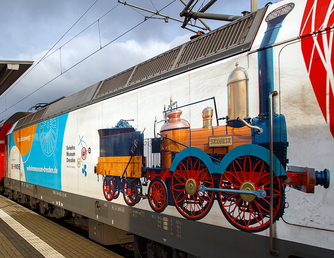 Detailbild: Die 146 025-2 (91 80 6146 025-2 D-DB) der DB Regio AG Südost als S 1 der S-Bahn Dresden nach Meißen-Triebischtal am 07.12.2022 im Bahnhof Radebeul Ost.

Die TRAXX P160 AC1trägt die schöne Werbung „Was dich bewegt - Verkehrsmuseum Dresden und der SAXONIA. Die Lokomotive SAXONIA der Leipzig-Dresdner Eisenbahn-Compagnie (LDE) war die erste funktionstüchtige in Deutschland gebaute Dampflokomotive. Zum 150. Jubiläum der Eröffnung der ersten deutschen Ferneisenbahn von Leipzig nach Dresden im Jahr 1989 wurde in Eigenleistung verschiedener Dienststellen der Deutschen Reichsbahn ein betriebsfähiger Nachbau gebaut, der heute im Verkehrsmuseum Dresden museal präsentiert wird.
