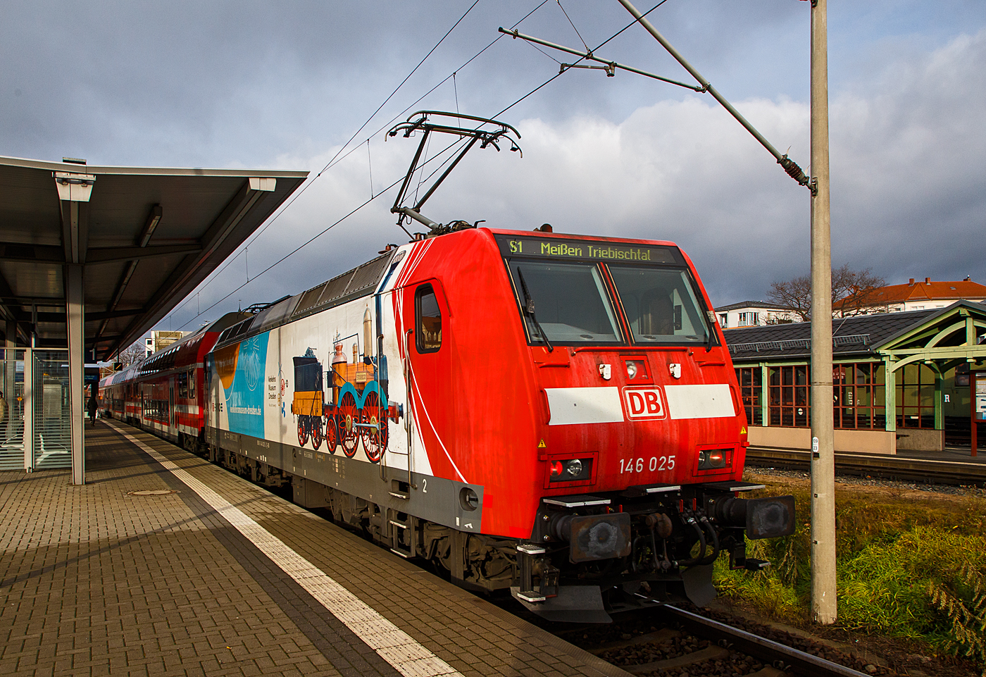 Die 146 025-2 (91 80 6146 025-2 D-DB) der DB Regio AG Südost verlässt am 07.12.2022, als S 1 der S-Bahn Dresden nach Meißen-Triebischtal, den Bahnhof Radebeul Ost.

Die TRAXX P160 AC1trägt die schöne Werbung „Was dich bewegt - Verkehrsmuseum Dresden und der SAXONIA. Die Lokomotive SAXONIA der Leipzig-Dresdner Eisenbahn-Compagnie (LDE) war die erste funktionstüchtige in Deutschland gebaute Dampflokomotive. Zum 150. Jubiläum der Eröffnung der ersten deutschen Ferneisenbahn von Leipzig nach Dresden im Jahr 1989 wurde in Eigenleistung verschiedener Dienststellen der Deutschen Reichsbahn ein betriebsfähiger Nachbau gebaut, der heute im Verkehrsmuseum Dresden museal präsentiert wird.

Die TRAXX P160 AC1 wurde 2002 von der Bombardier Transportation GmbH  in Kassel unter der Fabriknummer 33893 gebaut.