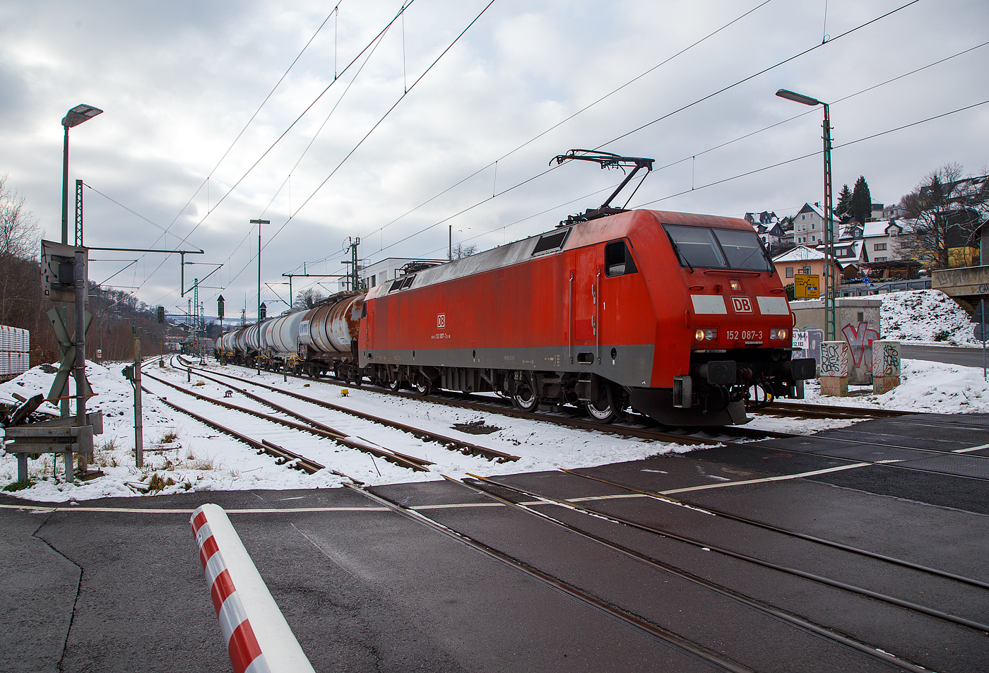 Die 152 087-3 (91 80 6152 087-3 D-DB) der DB Cargo AG fährt am 21.01.2023 mit einem Ethylendichlorid (Gefahrgut-Nr. 336/1184) beladenen Kesselwagenzug durch Niederschelden (Sieg) in Richtung Siegen.

Die Siemens ES64F wurde 2000 noch von Krauss-Maffei in München-Allach unter der Fabriknummer 20214 gebaut.

Die DB Baureihe 152 (Siemens ES64F):
Für den Güterverkehr benötigte die Deutsche Bahn Mitte der 1990er-Jahre dringend neue leistungsstarke Lokomotiven. Als Teil des  großen Beschaffungsprogramms für Triebfahrzeuge  der Deutschen Bahn AG wurde nach einer im Jahr 1993 erfolgten Ausschreibung über drei Lokomotivbaureihen 1995 ein Vertrag zwischen DB AG und Krauss-Maffei Verkehrstechnik GmbH (mit dem Partner Siemens) über die Lieferung von 195 Güterzuglokomotiven der oberen Leistungsklasse der Baureihe 152 geschlossen. Der Vertrag beinhaltet eine Option über 100 weitere Lokomotiven, die in direktem Anschluss an die erste Serie zu liefern wären, d. h. in den Jahren 2001 bis 2003.

Technische Basis des Angebots und des Vertrags war die gemeinsam von Krauss-Maffei und Siemens entwickelte EuroSprinter-Familie. Aufgrund des modularen Konzepts der EuroSprinter-Familie und der positiven Betriebserfahrungen in Spanien, Portugal und in Deutschland konnten die technischen Verhandlungen, ausgehend vom funktionalen Lastenheft der DB AG, sehr zielstrebig und effizient geführt werden.

Bei Bau und Entwicklung der neuen Lokomotiven wurde auf neueste Erkenntnisse der Technik Rücksicht genommen. Der Führerstand verfügt über eine Klimaanlage und sogar ein Getränke-Kühlfach für den Lokomotivführer. Zur besseren Sicht bei Dunkelheit wurden, wie auch bei der Baureihe 101, Fernscheinwerfer eingebaut. Interessant sind bei diesen Lokomotiven auch die außen liegenden Scheibenbremsen. Zum Schutz der Umwelt wurden umweltverträgliche Kühlmittel und Lacke auf Wasserbasis verwendet. Die Baureihe 152 hat sich seitdem sehr gut bewährt und läuft, im Gegensatz zur 101, auch weitgehend störungsfrei.

Die ersten vier Lokomotiven wurden bereits 1997 in Betrieb genommen und mit Zulassung des Eisenbahn-Bundesamtes (EBA) geliefert. Ab 1998 lief die Serienlieferung planmäßig. Die ersten zehn Lokomotiven wurden seit dem Fahrplanwechsel im Mai 1998 in einem zehntägigen Umlauf Padborg - Basel eingebunden. Sie zeigten bisher keine Auffälligkeiten und arbeiten zur Zufriedenheit des Betriebes.

Die Abnahmefahrten erbrachten die Bestätigung, dass die im Lastenheft geforderte Leistungsfähigkeit in den vollen Umfang realisiert wurde. Anlässlich einer Vorführfahrt in Österreich wurde die Leistung sogar auf 7 MW gesteigert. Teilweise wurden schwere Güterzüge mit nur drei Motoren gefahren und in keinem der Fälle wurden die thermischen Grenzwerte der Bauteile erreicht. Bei einer Vorführfahrt durch die Schweiz nach Italien wurde ein 3.200-t-Tonerde-Zug mit über 640 kN Anfahrzugkraft in Doppeltraktion ruckfrei angefahren. Damit konnten die bei der Leistungsauslegung eingebauten Reserven wirkungsvoll nachgewiesen werden.

Die BR 152 ging in den Lokomotivbestand von der DB Cargo AG (zeitweise unter Railion bzw. DB Schenker Rail firmiert) ein und sollte dort in erster Linie die sechsachsigen Lokomotiven der BR 150 bzw. 151 ersetzen. Die Lokomotive kann aber auch im Personenverkehr eingesetzt werden. So ist die BR 152 dank hoher Leistung und Zugkraft z.B. sehr gut für schwere Doppelstockzüge im Wendezugbetrieb geeignet.

Zur Auslieferung aller bestellten 195 Stück der 152er kam es allerdings nicht, da wegen einer geringfügigen Überschreitung der Achslasten bekam die neue Baureihe bei der Österreichischen Bundesbahn (ÖBB) keine Zulassung. Man musste handeln. Die neuen Lokomotiven wurden dringend für den Güterverkehr nach Österreichisch benötigt, für eine weitere Neuentwicklung waren weder Zeit noch Geld vorhanden. So wurde die Bestellung über die letzten 25 Stück der BR152 storniert und in die Zweisystemloks Siemens ES64U2 (baugleich mit ÖBB Reihe 1116 - Zweisystemloks „Taurus“) umgewandelt. Diese Lokomotiven wurden im Jahr 2001 ausgeliefert und sind seitdem als Baureihe 182 bei der DB Cargo AG im Dienst.

Konstruktion:
Die Baureihe basiert auf dem von Siemens konstruierten Prototyp ES64P (127 001). Da jedoch klar war, dass die Maschinen doch ausschließlich im Güterverkehr eingesetzt werden sollten und eine Höchstgeschwindigkeit von 140 km/h als ausreichend angesehen wurde, konnte auf die Verwendung von voll abgefederten Fahrmotoren verzichtet und auf den wesentlich einfacheren und preisgünstigeren Tatzlager-Antrieb zurückgegriffen werden. Dieser gilt durch die Verwendung moderner Drehstrommotoren bei niedrigen Geschwindigkeiten als relativ verschleißarm. Die Kraftübertragung zwischen Wagenkasten und Drehgestellen erfolgt in Maffei-Tradition über kräftig dimensionierte und tief herunterreichende Drehzapfen sowie Flexicoilfedern.

Ansonsten entstand eine moderne Maschine mit Drehstromasynchron-Fahrmotoren und doppelten innenbelüfteten Scheibenbremsen. Eine teilredundante Ausführung von hochbeanspruchten Teilen im Antriebsstrang trägt ganz wesentlich zur hohen Zuverlässigkeit und Verfügbarkeit der Baureihe bei.

Der Haupttransformator ist unterflur zwischen den Drehgestellen angeordnet. Jedes Drehgestell verfügt über eine autarke elektrische Ausrüstung, bestehend aus drei Eingangsgleichrichtern in rückspeisefähiger Vierquadranten-Bauweise, Gleichspannungszwischenkreis und zwei Wechselrichtern (einer je Motor). Dadurch wird erreicht, dass bei Ausfall einer Komponente des Antriebsstrangs nicht das gesamte Drehgestell ausfällt, sondern sich lediglich die verfügbare Zugkraft reduziert. Als Leistungshalbleiter kommen wassergekühlte GTO-Thyristoren zum Einsatz. Die Bremskraft der elektrodynamischen Nutzbremse beträgt 150 kN im Bereich zwischen 10 km/h und 140 km/h.

Die Lokomotiven sind mit Zugsammelschiene für die Energieversorgung von Reisezügen sowie Wendezugsteuerung und Notbremsüberbrückung ausgerüstet, so dass sie auch im schweren Personenzugdienst eingesetzt werden können. Durch die Aufteilung der DB AG und Zuordnung der Loks zum Geschäftsbereich Güterverkehr der DB wurde davon seit Ende der 1990er Jahre kein Gebrauch mehr gemacht.

Der Maschinenraum wird von einem beide Führerstände verbindenden Mittelgang durchzogen. Beidseitig sind an den Außenwänden des Lokkastens die elektrische Ausrüstung, die Druckluft- und Bremsgeräte sowie die umfangreichen Kühleinrichtungen angeordnet. Alle Aggregate sind in Form von separaten, austauschbaren Modulen ausgeführt, die von oben in das Fahrzeug eingebracht werden. Dabei wurde auf möglichst kurze Verbindungen, insbesondere bei den Hauptstromleitungen geachtet. Die Steuerleitungen und die Verrohrung sind in Kanälen unter dem Mittelgang verlegt. Die Steuerungs- und Überwachungsgeräte sind an den beiden Enden des Maschinenraums konzentriert.

Die Führerstandsräume sind klimatisiert, wärme- und schallisoliert und verfügen über ein recht großzügiges Raumangebot. Annehmlichkeiten für den Triebfahrzeugführer sind darüber hinaus ein luftgefederter Sitz und ein Thermofach. Die Lokomotiven sind mit Einheitsführerständen ausgerüstet.

TECHNISCHE DATEN der BR 152 (Siemens ES64F):
Hersteller: Krauss-Maffei bzw. Siemens 
Baujahre: 1996-2001
Gebaute Anzahl: 170
Spurweite: 1.435 mm (Normalspur)
Achsformel: Bo´Bo´
Länge über Puffer: 19.580 mm
Drehzapfenabstand: 9.900 mm
Achsstand im Drehgestell: 3.000 mm
Treibraddurchmesser: 1.250 mm (neu) / 1.170 mm (abgenutzt)
Breite: 3.000 mm
Dienstgewicht: 86,7 t
Achslast: 21,75 t
Höchstgeschwindigkeit: 140 km/h
Dauerleistung: 6.400 kW (8.701 PS)
Anfahrzugkraft: 300 kN
Dauerzugkraft: 250 KN
Fahrmotoren: 4 Stück fremdbelüftete vierpolige Drehstrom-Asynchron-Motoren
Getriebeübersetzung: 3,95:1
Antriebsart: integrierter Tatzlagerantrieb
Stromabnehmer: SSS 87 (Einholm)
Stromsystem: 15 kV, 16 2/3 Hz

Elektrisches Antriebssystem: Wassergekühlte GTO-Stromrichter, 3 netzseitige Eingangsgleichrichter (4QS),
Gleichspannungszwischenkreis, 1 Pulswechselrichter pro Fahrmotor, Einzelachsregelung mit 75% Redundanz-

Steuerungs- und Leittechnik: 2 Zentrale Steuergeräte in SIBAS 32 mit integrierter AFB, ZWG, SIFA und zentraler Diagnose, 1 Farbdisplay und MFA pro Führerstand, LZB 80, Gleit- und Schleuderschutz K-Micro.

Bremsausrüstung: Elektrische Netzbremse, Knorr-Führerbremsventilanlage Typ HSM-MEP, Radscheibenbremse, 4 Federspeicher-Festhaltebremsen
