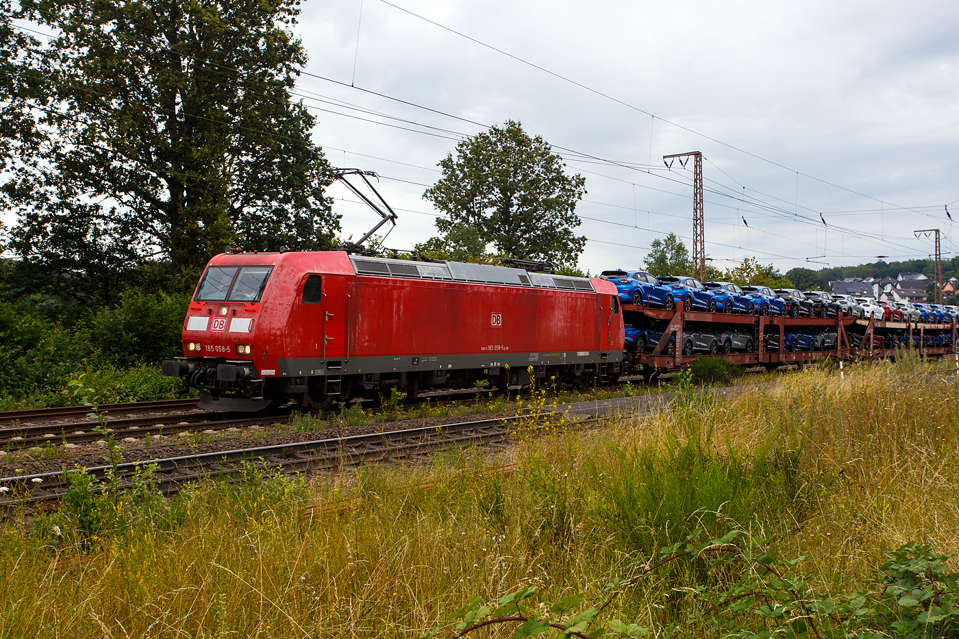 Die 185 058-5 (91 80 6185 058-5 D-DB) der DB Cargo AG fährt am 11 Juli 2024 mit einem langen beladen Autotransportzug (Wagen der Gattung Laaeks 553 der DB Cargo Logistics GmbH, ex ATG), durch Wilnsdorf-Rudersdorf (Kreis Siegen) in Richtung Siegen bzw. Kreuztal.

Nochmals einen lieben Gruß an den netten grüßenden Lokführer zurück, mich freuen immer die Grüße.

Die TRAXX F140 AC1 wurde 2002 von Bombardier in Kassel unter der Fabriknummer 33467 gebaut.
