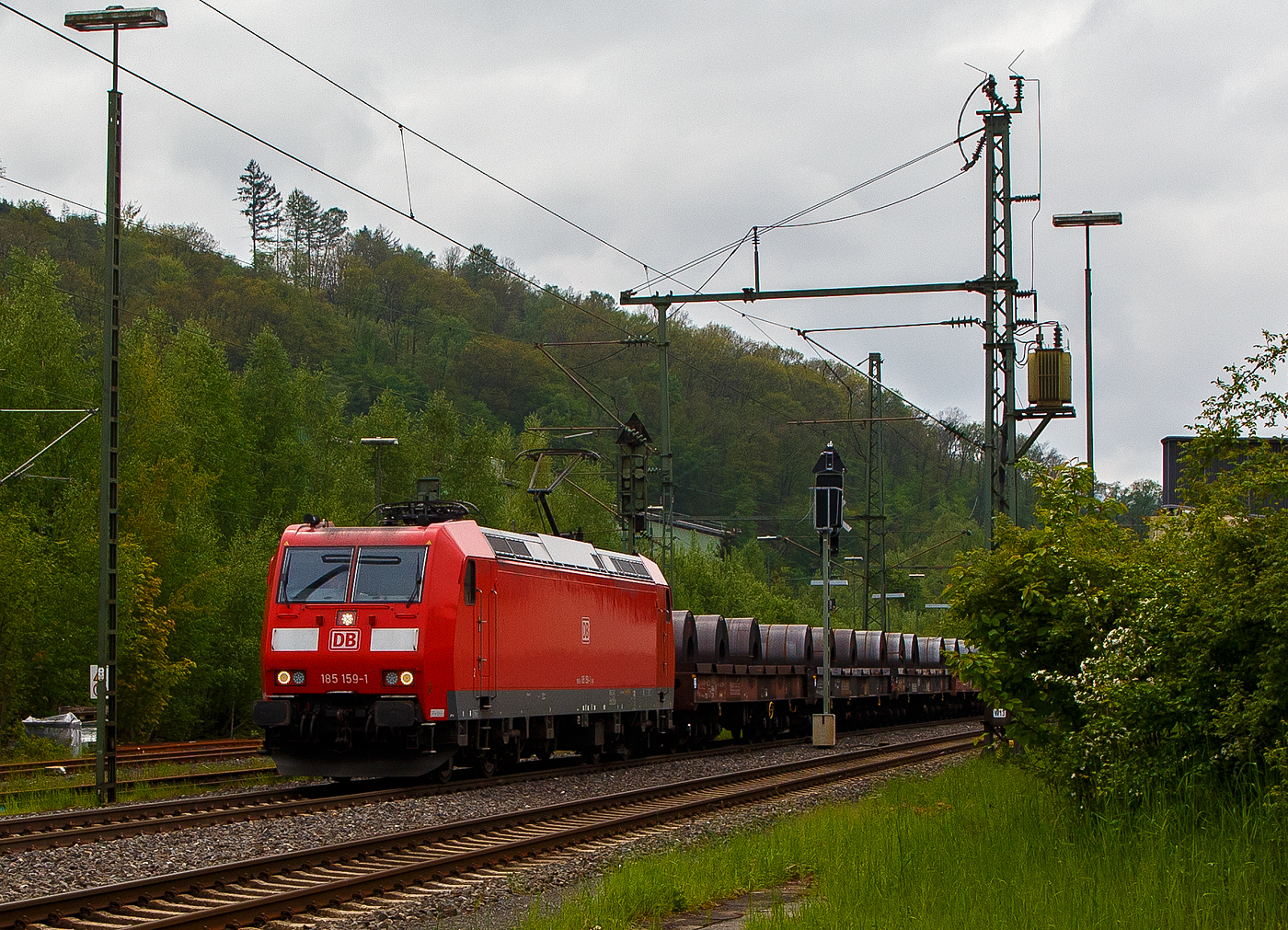 Die 185 159-1 (91 80 6185 159-1 D-DB) der DB Cargo AG fährt am 11.05.2023, mit einem Warmband-Coilzug (offene sechsachsige Wagen der Gattung Sahmms etc.), durch Niederschelden in Richtung Siegen bzw. Kreuztal.

Die TRAXX F 140 AC1 wurde 2003 von der Bombardier Transportation GmbH in Kassel unter der Fabriknummer 33632 gebaut.