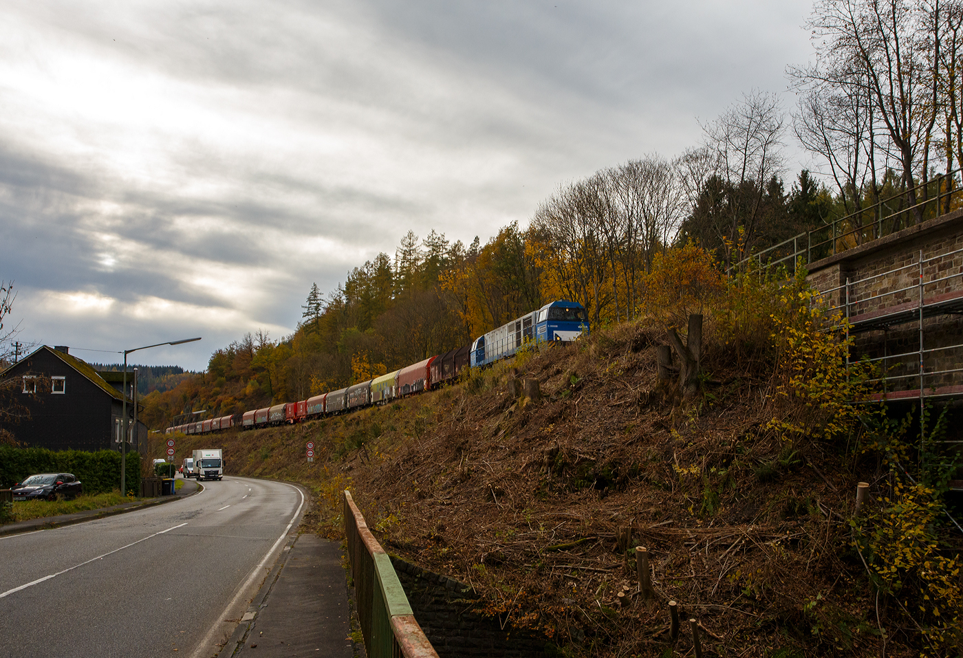 Die an die KSW vermietete 272 409-4 / D21 (92 80 1272 409-4 D-BE) der Bentheimer Eisenbahn, ex Rurtalbahn V 204 (92 80 1272 409-4 D-RTBC), eine Vossloh G 2000 BB (mit symmetrischem Führerhaus), fährt am 31 Oktober 2025, von Betzdorf kommend, mit ihrem Coilzug zwischen Sassenroth und Herdorf in Richtung Bahnhof Herdorf bzw. KSW Rbf Herdorf (Betriebsstätte Freien Grunder Eisenbahn).