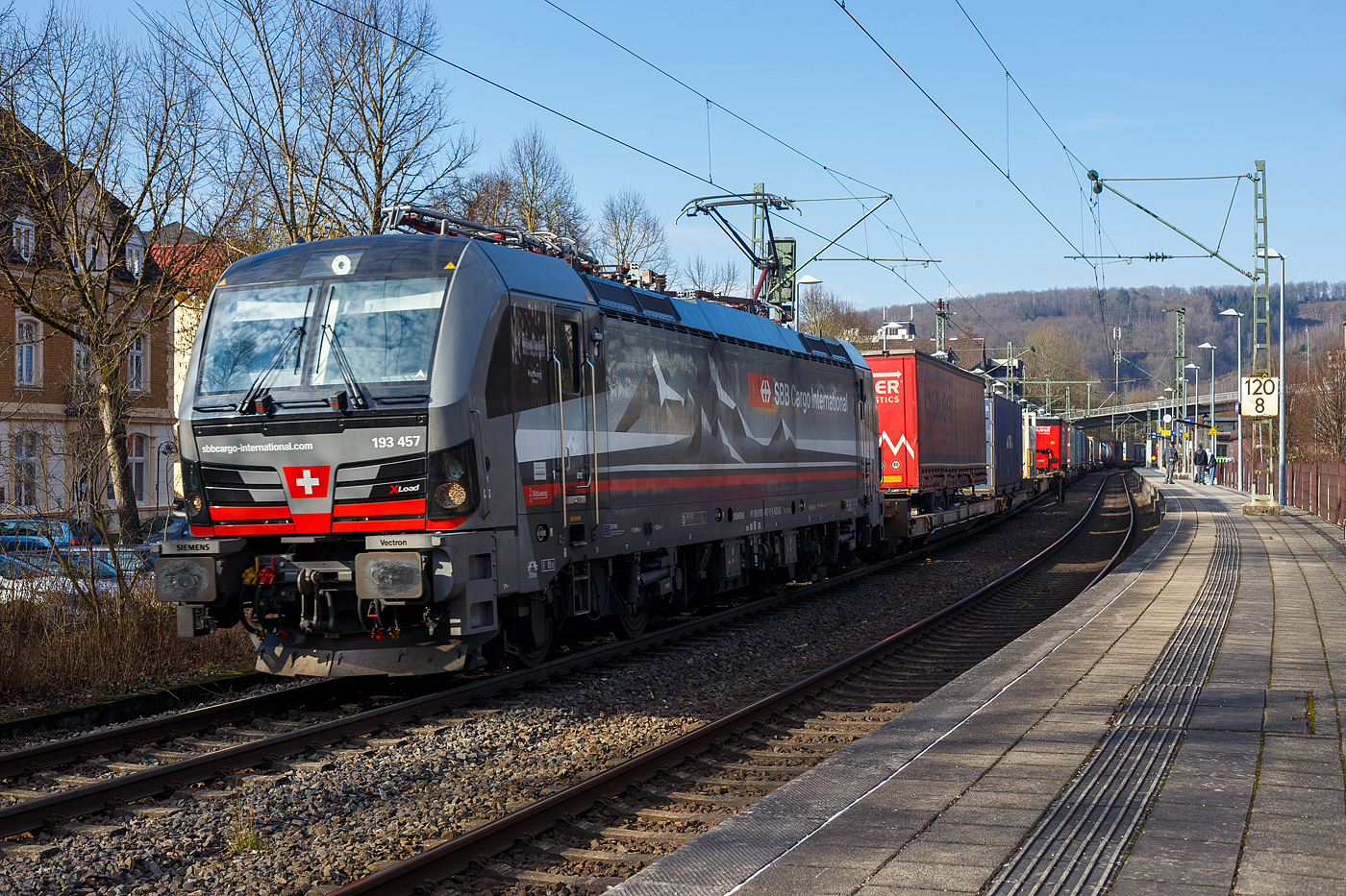 Die an die SBB Cargo International AG vermietete mit „XLoad“ ausgestattete 193 457  Hofburg Wien  (91 80 6193 457-9 D-SIEAG) der SüdLeasing GmbH, Stuttgart (eingestellt in Deutschland durch Siemens) fährt am 08 Februar 2025 mit einem KLV-Zug, durch Kirchen (Sieg) in Richtung Köln.

Die Multisystemlokomotive Siemens Vectron MS wurde 2024 von Siemens Mobilitiy in München-Allach unter der Fabriknummer 23785 gebaut und am 12.09.2024 ausgeliefert. Sie wurde in der Variante A40-1a ausgeführt und hat so die Zulassung für Deutschland, Österreich, die Schweiz, Italien, die Niederlande und Belgien (D / A / CH / I / NL / B). Sie verfügt über eine Leistung von 6,4 MW (160 km/h) und ist neben den nationalen Zugsicherungssystemen mit dem Europäischen Zugsicherungssystem (ETCS BL3) ausgestattet. Zudem ist sie mit der neuen Ausrüstungspaket XLoad ausgestattet. 

Das neue XLoad Ausrüstungspaket für Vectron:
XLoad ist ein Ausrüstungspaket für Vectron, welches künftig mitbestellt, aber auch bei bereits ausgelieferten Vectron Loks nachgerüstet werden kann. Das Feature verbessert die Reibwertausnutzung und ermöglicht dadurch höhere Anhängelasten. Zudem reduzieren die Fahreigenschaften, die das Feature bewirken, den Verschleiß von Rad und Schiene.

Aktuell sind die Schweizer Vectron-Lokomotiven (SBB Cargo und BLS Cargo) in der Regel in Doppeltraktion unterwegs. Die Steigungen und Rampen der Schweizer Berge sind vor allem bei schlechten Witterungsbedingungen nicht ohne. Eine Lokomotive muss auch bei geringerem Schlupf genügend Traktion auf die Schienen bringen, um alle Güter sicher und zuverlässig ans Ziel zu bringen. Ein effizienter Weg aus dieser «Misere» ist die für Vectron entwickelte Zusatz-Funktion «XLoad». Den erfolgreichen Beweis trat eine SIEMENS Testlokomotive im Frühjahr 2022 bei der SBB Cargo International und bei der BLS Cargo eindrücklich an. 

Für SBB Cargo International bewies die Test-Lokomotive am Bözberg und für BLS Cargo an der Nordrampe des Lötschbergs ihre enorme Zugkraft. 
Vectron meisterte im Frühjahr 2022 die lange 12‰-Steigung des Bözbergs mit einer Anhängerlast von 2.000 Tonnen bravourös. Bei den nächtlichen Testfahrten zeigte sich eindrücklich die enorme Zugkraft der Lokomotive. 

Am Lötschberg wurden bei der BLS Cargo steigungsmäßig noch ein paar Promille draufgepackt. Mit 1.020 Tonnen im Gepäck bewältigte die Vectron-Lokomotive mit XLoad-Feature die 27‰-Steigung der Nordrampe ebenfalls meisterlich. Und auch diverse Anfahrtsversuche absolvierte der mit dem XLoad-Feature aufgerüstete Vectron problemlos. 

So bestellte die SüdLeasing GmbH (Stuttgart) im Auftrag der SBB Cargo International jüngst 20 Vectron Lokomotiven mit XLoad bei SIEMENS.