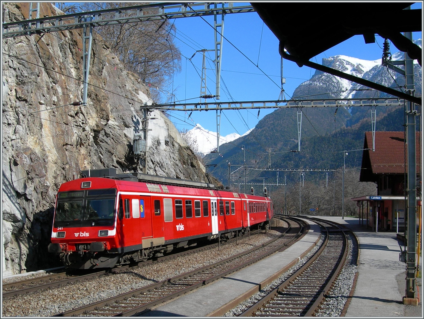 Die von bei der Fusion von der RM übernommen RBDe 566 Pendelzüge fuhren einige Zeit im RM Rot als BLS Regionalzüge. Mit dem dem schiebenden RBDe 566 241 verlässt der Regionalzug von Goppenstein nach Brig den Bahnhof Lalden.

16. März 2007