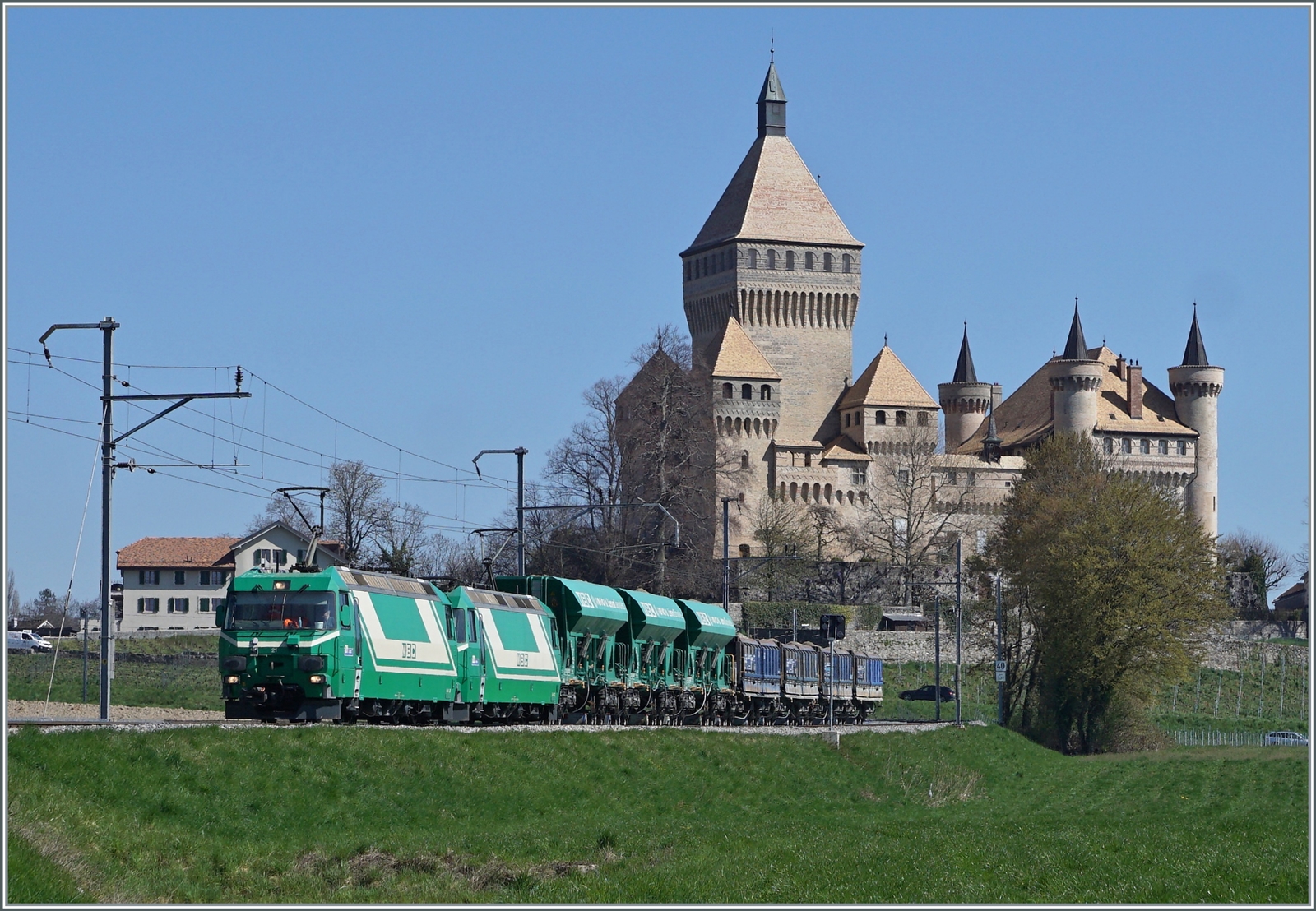Die beiden BAM MBC Ge 4/4 21 und 22 sind mit ihrem Kieszug Apples - Morges - Gland bei Vufflens le Château unterwegs. Den Hintergrund prägt das zauberhafte Schloss von Vufflens. 

5. April 2023