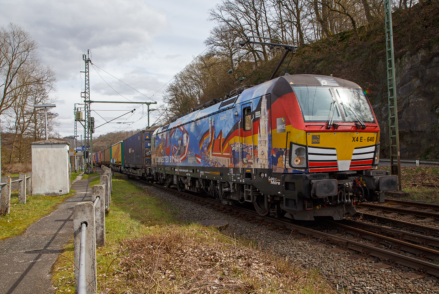 Die bunte und schöne an die TX Logistik AG vermietete Siemens Vectron MS X 4 E – 640 / 193 640-0 “Connected by Rail” (91 80 6193 640-0 D-DISPO) der MRCE Dispolok GmbH (München) fährt am 28.03.2023, mit einem KLV-Zug, durch Scheuerfeld (Sieg) Richtung Köln. 

Die Siemens Vectron MS - 6.4 MW wurde 2016 von Siemens in München-Allach unter der Fabriknummer 22164 gebaut. Sie hat die Zulassungen für Deutschland, Österreich und Italien, daher trägt sie auch die Werbung München, Kufstein, Verona (Connected by Rail). Sie hat eine Höchstgeschwindigkeit von 160 km/h.
