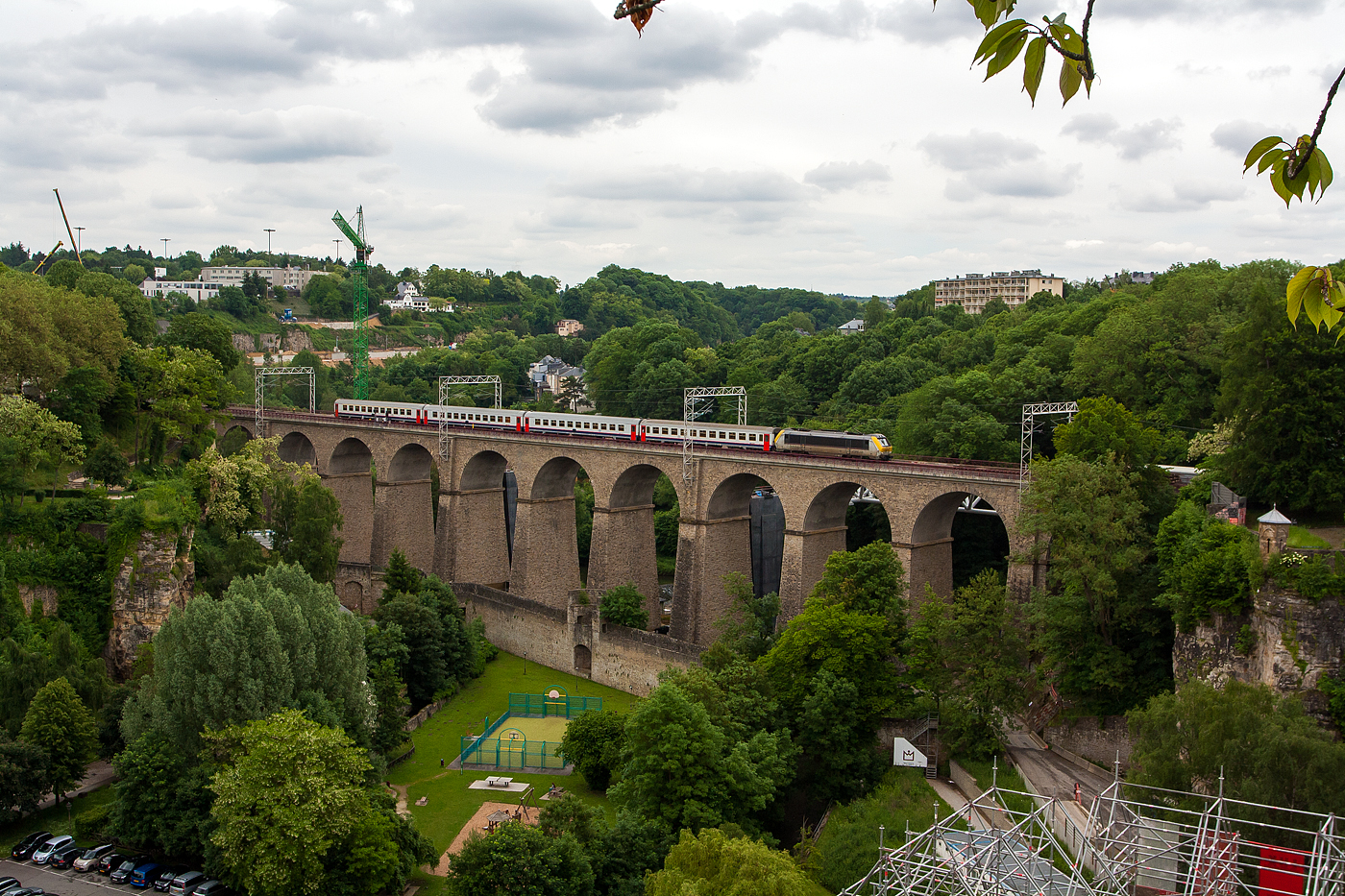 Die CFL 3006 mit einem IR von Liers fährt am 14 Juni 2013 über das Pulvermühle Viadukt (auch Bisserweg Viadukt genannt) und erreicht so bald den Bahnhof Luxemburg (Gare de Luxembourg).  

Dieser Viadukt, hat eine Länge von 242 Meter und 13 Bögen von 15 Meter Durchmesser. Damals war er noch 2-gleisig, Daneben wurde eine weitere moderne Brücke für 2 Gleise neu gebaut, leider aber nicht als Viadukt in dieser Steinbauweise.