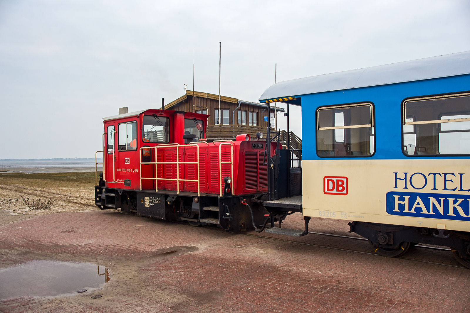 Die DB 399 108-0 (98 80 3399 108-0 D-DB) der Wangerooger Inselbahn am 12 März 2024, mit dem Personenzug und zwei Flachwagen (für Gepäckcontainern) nun ganz leer, Westanleger Wangerooge zum Bahnhof Wangerooge, durch die Salzwiesen, zurück. 