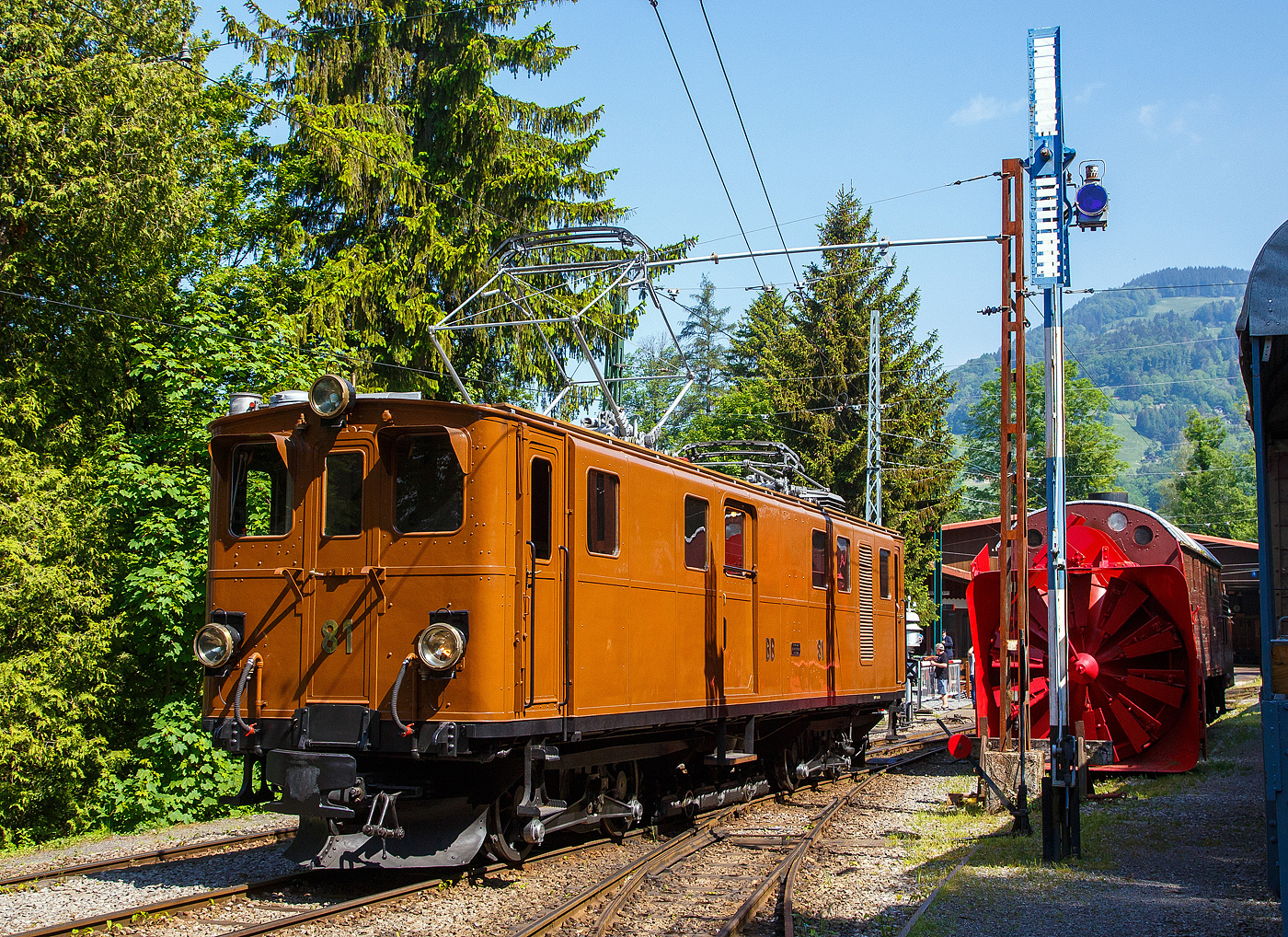 Die grandiose ehemalige Berninabahn RhB Ge 4/4 81 der Museumsbahn Blonay–Chamby, ex RhB Ge 4/4 181, ex BB Ge 4/4 81, ex BB Ge 6/6 81, am 27. Mai 2023 beim Umsetzen auf dem Museums-Areal der (BC) in Chaulin. 

Rechts ein Schweizer Rangiersignal (Räumungssignal), welches hier zeigt „Rangieren gestattet“ (im Gültigkeitsbereich des Signals ist keine Zufahrtsstraße eingestellt). Bei Rangieren verboten wären die Flügel zu einem X gekreuzt. 

Hinter dem Signal ein weiteres Relikt der Berninabahn, die Selbstfahrende Dampfschneeschleuder R 1052 (ex BB R 1052 (Berninabahn), ex RhB R 14, ex RhB Xrot d 9214) der Museumsbahn Blonay-Chamby.
