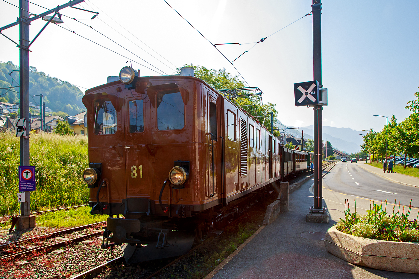 Die Lok muss nun ans andere Ende vom Zug, so wird der Wagenzug wieder etwas hochgedrckt. Die ehemalige Berninabahn BB Ge 4/4 81 der Museumsbahn Blonay–Chamby, ex RhB Ge 4/4 181, ex BB Ge 4/4 81, ex BB Ge 6/6 81, drckt am 27.05.2023 den Zug hinter die Weiche. Nach dem Abkuppeln fhrt die Lok (BB Ge 4/4 81) allein aufs linke Gleis, danach rollt (ohne Antrieb, von einer Bremserbhne gebremst) der reine Wagenzug, aufs vordere Gleis in den Bahnhof. 