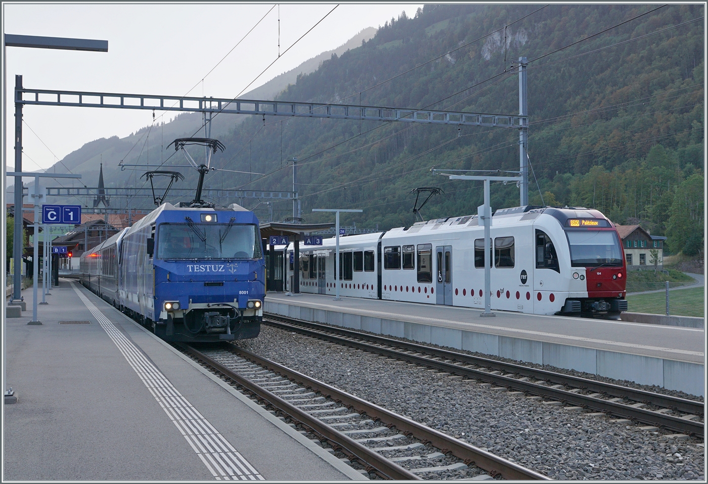 Die MOB Ge 4/4 8001 ist mit dem GoldenPass Express GPX 4064 in Montbovon auf dem Weg nach  Interlaken Ost. Rechts im Bild ein TPF SURF nach Palézieux. 

24. Aug. 2023