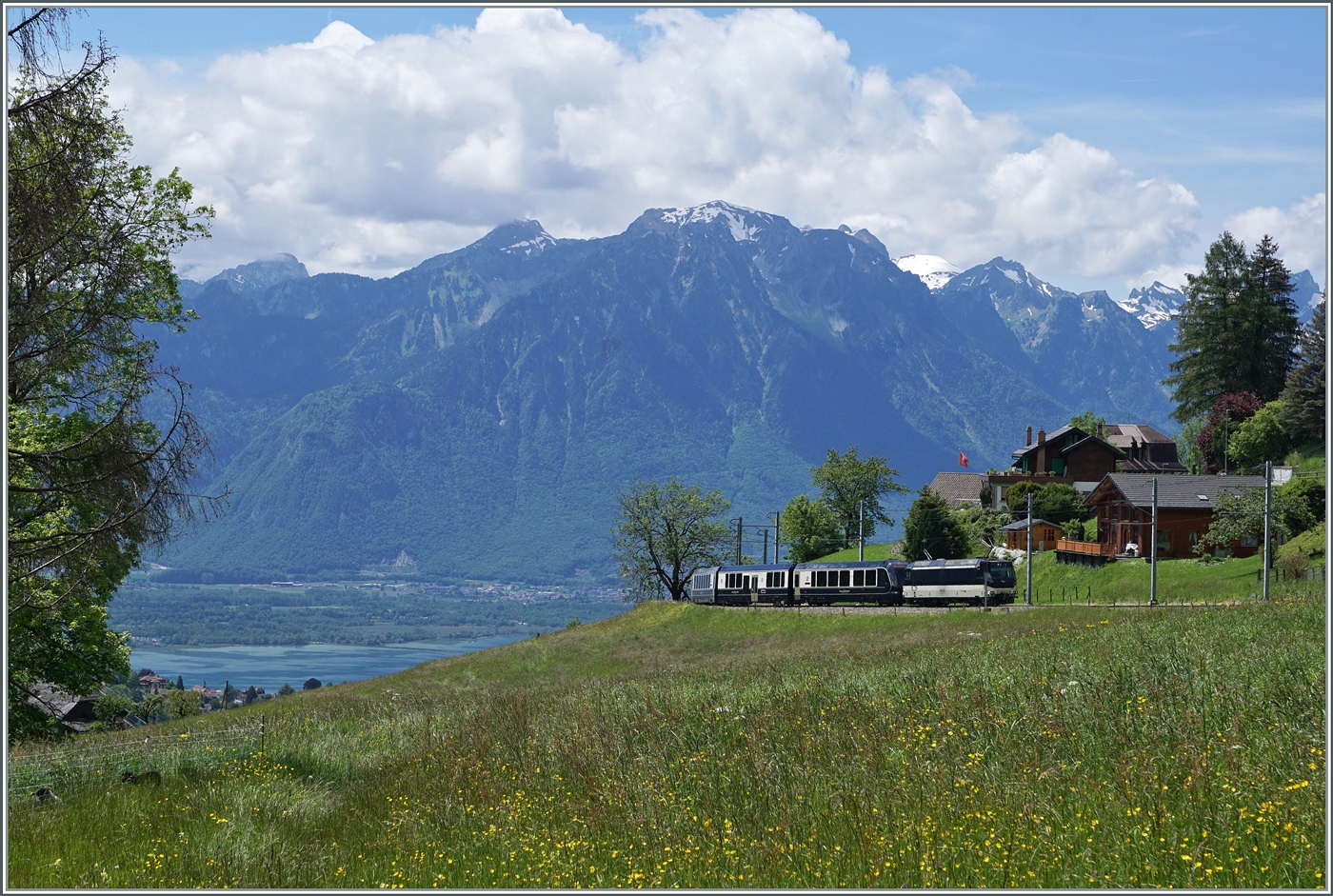 Die MOB Ge 4/4 8004 erreicht mit ihrem GoldenPass Express GPX 4074  Les Avants. Der Zug ist von Montreux nach Interlaken Ost unterwegs, in Zweisimmen wechselt der Zu die Lok und Spur. Neuerdings verkehrt der GPX fünfteilig, d.h. ein Niederflurwagen wurde nun in den Zugsverband eingesetzt. 

Das Bild zeit neben relativ wenig Zug um so mehr Landschaft, links im Bild ist sogar noch ein Zipfelchen des Genfer Sees zu sehen.

28. Mai 2024