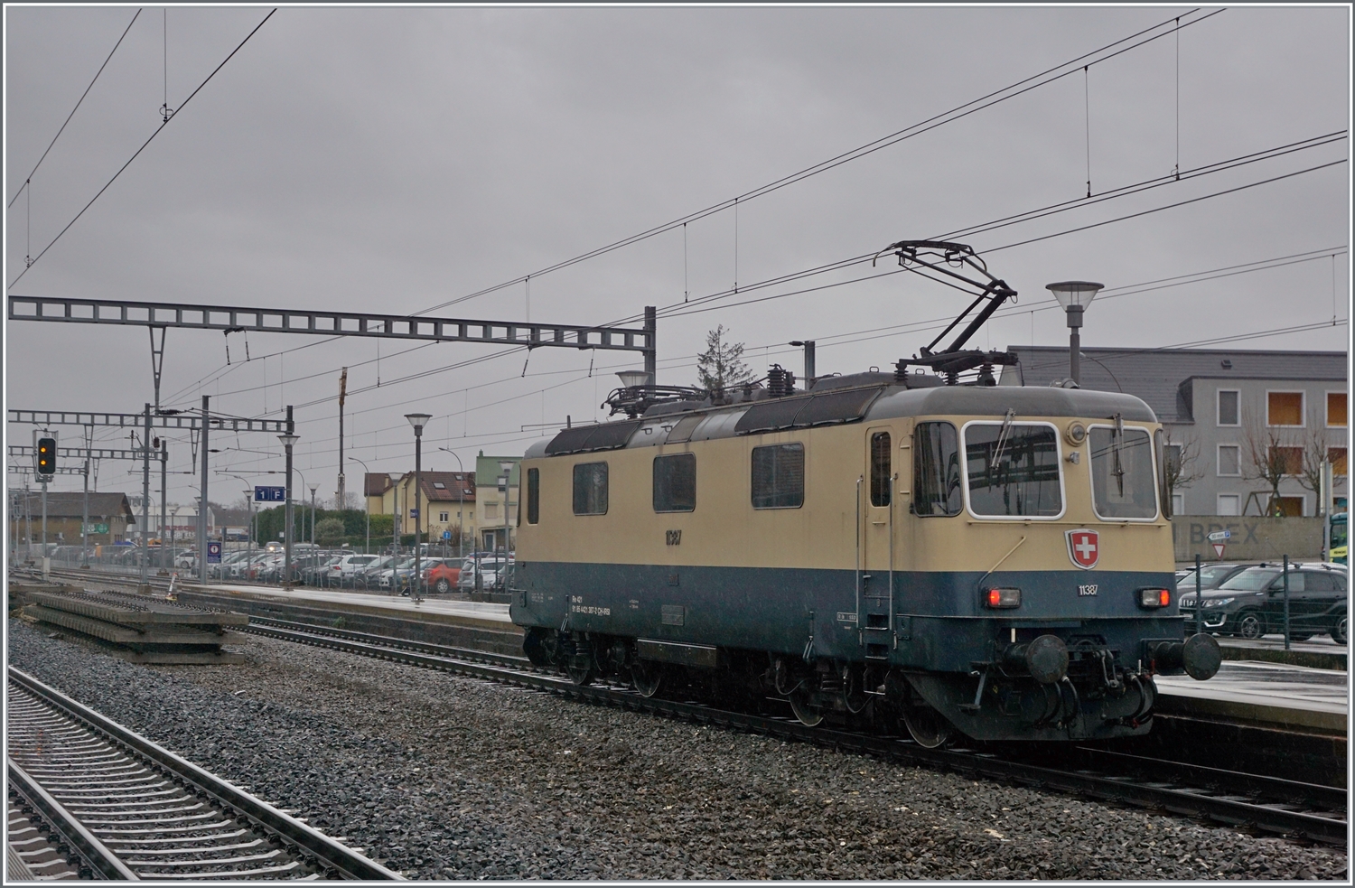 Die von Morges gekommene IRSI Re 4/4 11387 ist in Gland angekommen. Besonders die vier letzten Kilometer sind betrieblich eine Herausforderung, da die Lok von der Dienststation bei Bursinel im Wechselbetrieb auf dem rechten Gleis nach Gland fahren muss, was bei sieben Züge pro Stunde in der Gegenrichtung eher wenig Spielraum lässt. So ist nun die Lok dabei, das Gleis zu räumen, unmittelbar darauf wird der IC1 Genève - St.Gallen hier durchfahren. 

Die Re 4/4 II 11387 wird auf ein Industriegleis in Richtung Kieswerk geleitet, um dort ihren Zug nach Apples abzuholen. Die angemietete IRSI/IGE Re 4/4 II 11387 (Re 421 387-2) ersetzt die zur Zeit in der Revision in Bellinzona weilende BAM MBC MBC Re 420 506. 

22. Feb. 2024