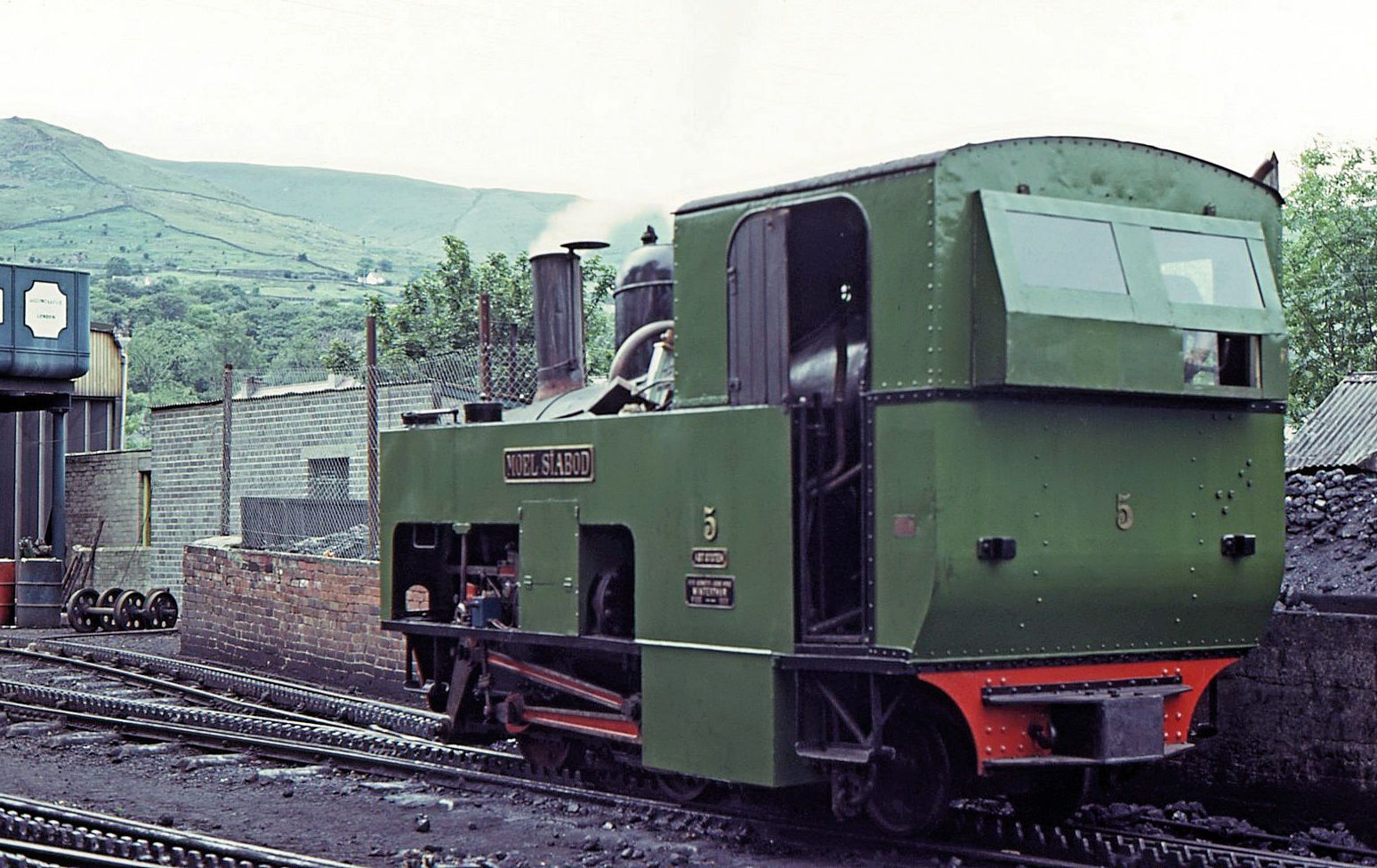 Die Original-Lokomotiven von 1895/96 (SLM Winterthur) für die Snowdon Mountain Railway / Rheilffordd yr Wyddfa: Lok 5  Moel Siabod  (Name eines nahegelegenen markanten Berges) ist 2017 nach fast zwanzigjährigem Stillstand und grosser Revision als besonders schöne Dampflok wieder in Betrieb gekommen. Hier steht sie in Llanberis am 21.Juli 1974 