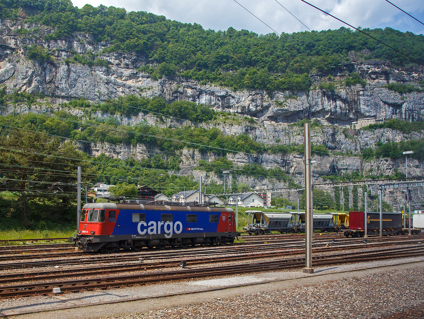 Die Re 620 021-6 “Taverne-Torricella“ (91 85 4620 021-6 CH-SBBC) der SBB Cargo AG, ex SBB Re 6/6 – 11621, ist am 28.05.2023 beim Bahnhof St-Maurice abgestellt, aufgenommen aus dem Zug heraus.

Die Re 6/6 wurde 1976 von der SLM in Winterthur (Schweizerische Lokomotiv- und Maschinenfabrik) unter der Fabriknummer 5008 gebaut, der elektrische Teil ist von BBC. Führerstands-Klimaanlagen wurden nachträglich eingebaut.