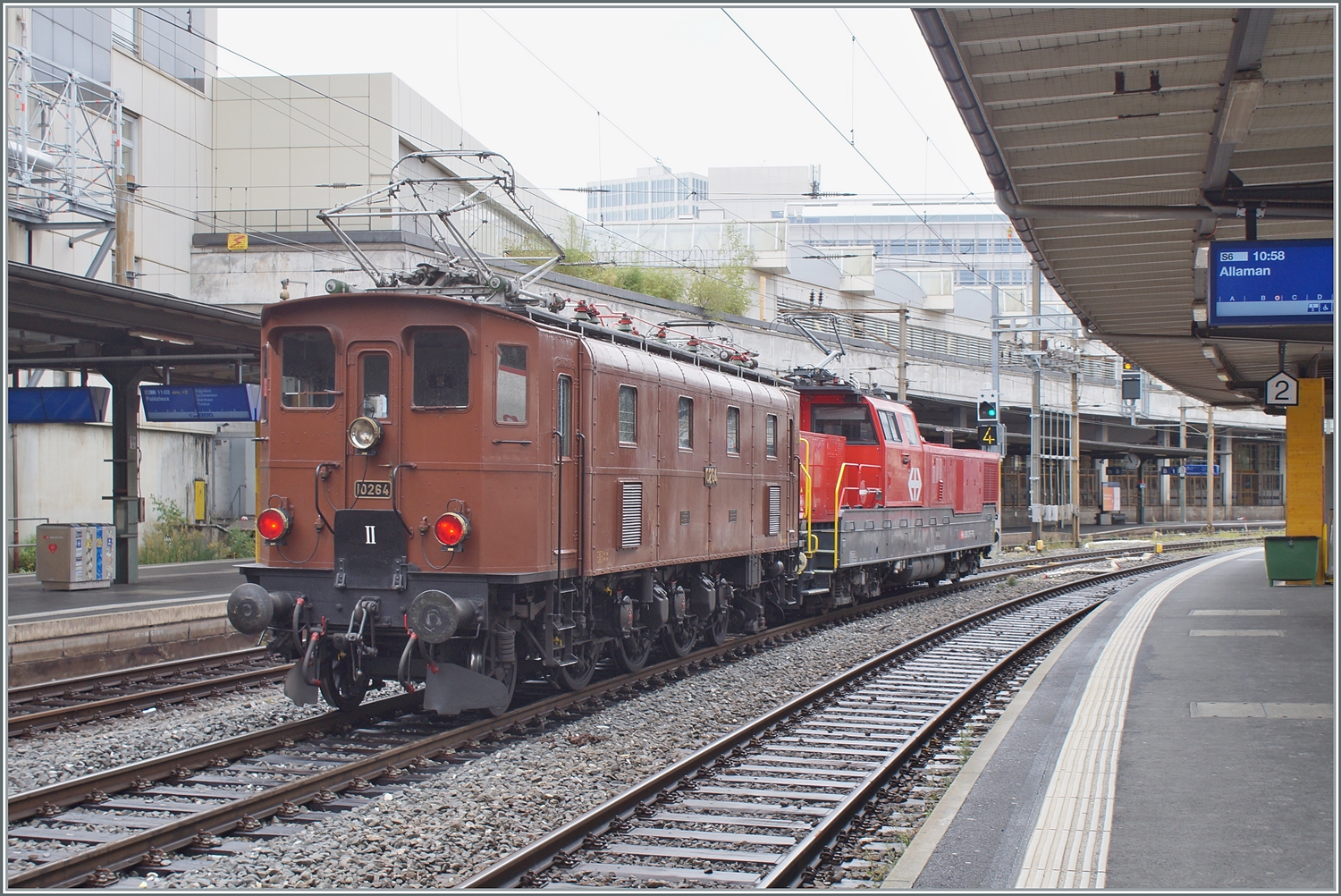 Die SBB Historic Ae 3/6 III 10264 schiebt in Lausanne ein mächtiges ETCS Gerät in Form einer Aem 940 vor sich her. Die Lok ist wohl auf der Rückfahrt vom Dépôt Fest in Olten nach St-Maurice. In den Jahren 1925 und 1926 wurden die kleine Serie der elf Ae 3/6 III 10261 - 10271 gebaut, die 89 Tonnen schwere Lok hatte eine Höchstgeschwindigkeit von Km/h 90 und 1800 PS. Die Lok wurde entwickelt, da recht kurzen Ae 3/5 bei hoher Geschwindigkeit schlechte Fahreigenschaften aufwiesen, somit wurde die Konstruktion der Ae 3/5 einfach verlängert und als Ae 3/6 III in Dienst gestellt. Interessanterweise wurden die letzten Ae 3/5 erst 1983 ausrangiert, die letzte Ae 3/6 III 1980. 2

28. August 2023