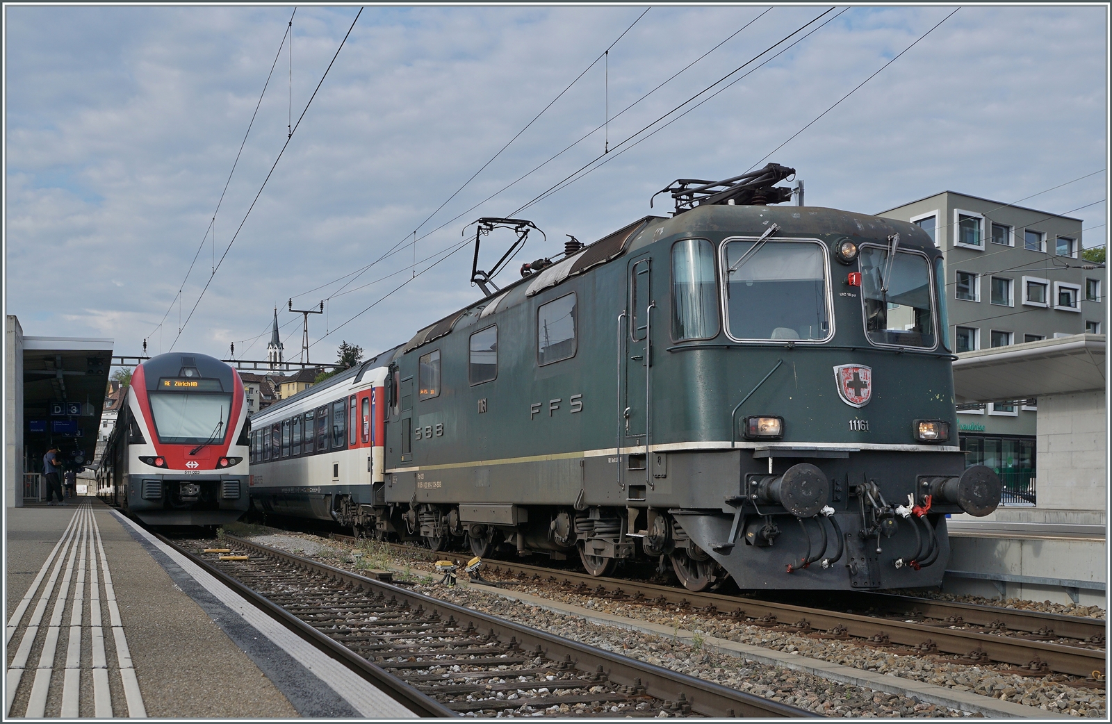 Die SBB Re 4/4 II 11161 in ihrer grünen Lackierung mit einem IC Zürich - Singen wartet in Schaffhausen auf die Abfahrt. Die grüne Farbe ist übrigens NICHT die Ursprungs-Lackierung der Re 4/4 II 11161, die Lok wurde 1967 in TEE Farben ausgeliefert und bekam erst nach dem Ende des TEE-Einsatzes 1981/82 die heutige grüne Lackierung. 

6. September 2022