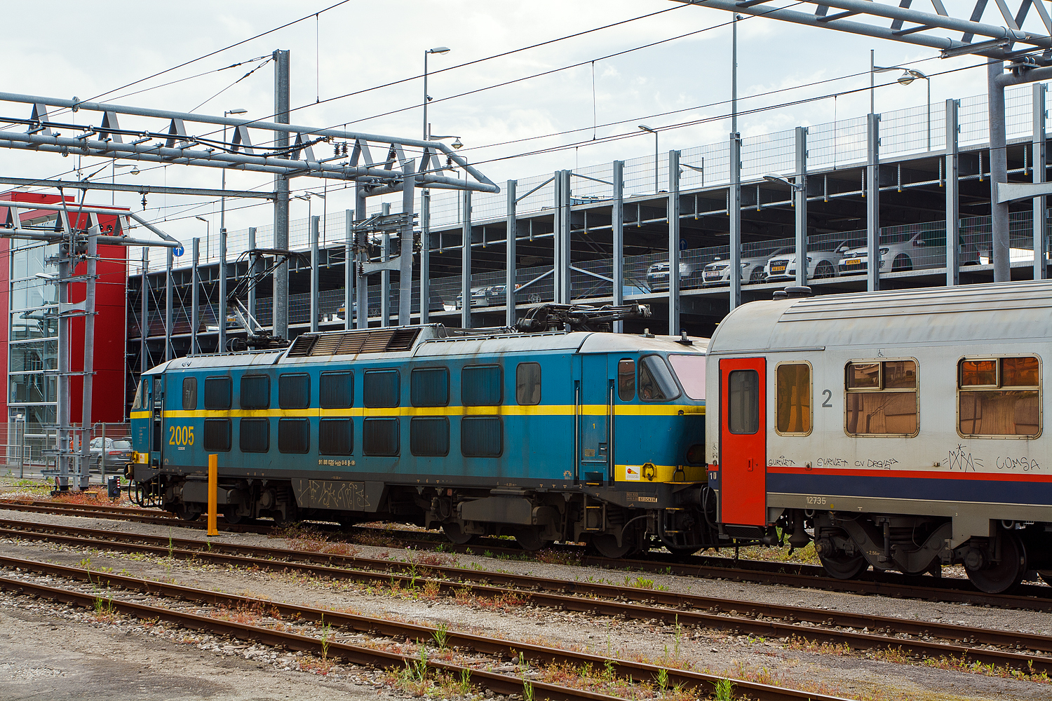 Die sechsachsige Co'Co' NMBS/SNCB 2005 steht am 14 Juni 2013 mit 2 belgischen Reisezugwagen beim Bahnhof Luxemburg Stadt (Gare de Luxembourg). Sie wird gleich den Eurocity EC 90 „Vauban“ (Chur – Z�rich – Basel – Stra�burg – Luxemburg – Br�ssel) �bernehmen, um die 2 Wagen verl�ngern und ihn von Luxemburg nach Br�ssel ziehen. 

Die Reihe 20 ist eine Baureihe sechsachsiger elektrischer Co'Co' Lokomotiven der NMBS/SNCB, die von BN - La Brugeoise et Nivelles hergestellt wurde. Die Loks der S�rie 20 waren damals 2013 schon fast alle aus dem Verkehr gezogen, einige dienten noch als Reserveloks und ironischerweise musste eine HLE 20 dann einspringen, wenn eine HLE 13 (die nachfolgende Baureihe f�r die EC Vauban/Iris) ausfiel.  

Die Loks der Reihe/Reeks 20 wurden zwischen 1975 und 1978 in zwei Baulosen bei BN (La Brugeoise et Nivelles) in Nivelles gebaut. Der elektrische Teil der Lok stammt von ACEC (Ateliers de contruction �lectriques de Charleroi). Das erste Baulos umfa�te in den Jahren 1975 und 1976 die ersten f�nfzehn Lokomotiven dieser Baureihe. 1977 und 1978 wurde eine zweite Serie mit zehn Loks gefertigt. Als letztes Fahrzeug ging 2025 Anfang 1978 in Dienst. Numeriert wurden die Loks fortlaufend von 2001 bis 2025.

Im elektrischen Teil sind die Loks mit einer Thyristorsteuerung ausgestattet, die aus einem fehlgeschlagenen Versuchsaufbau einer Viersystemlok hervorgegangen ist. Mit ihrer beachtlichen Leistung von �ber 5.000 kW war die Baureihe 20 in der Mitte der siebziger Jahre die st�rkste thyristorgesteuerte Lok weltweit. Die Loks der Reihe 20 waren die einzigen Co'Co' im Bestand der SNCB. Die HLE 20 durften nicht in Doppeltration fahren, da ihre Leistung beim Anfahren so gro� ist, dass das Risiko bestand, dass die Verbindung zwischen der zweiten Maschine und dem ersten Wagen bricht.

Ihren Einsatz sollten die Loks im schweren Personen- und G�terverkehr finden. Speziell auf der anspruchsvollen Strecke von Br�ssel �ber Namur nach Luxemburg sollte die Lok ihre St�rke ausspielen. 

Kurzzeitig erfolgten auch Fahrten der Lokomotiven auf der grenz�berschreitenden Strecke bis Aachen Hauptbahnhof, die auf dem deutschen Streckenabschnitt mit Oberleitung deutscher Bauart unter belgischem Stromsystem ausgestattet ist. Bei diesen Fahrten stellte sich jedoch heraus, dass der Stromabnehmer der Reihe 20 nicht mit der deutschen Oberleitung kompatibel war, der Einsatz auf deutschem Gebiet wurde daraufhin unterbunden.

TECHNISCHE DATEN der NMBS/SNCB-Reihe 20:
Baujahre: 1975-1978
Hersteller: BN, elektrischer Teil ACEC
Nummerierung: 2001-2025
St�ckzahl: 25
Spurweite: 1.435 mm (Normalspur)
Achsfolge: Co'Co'
L�nge �ber Puffer: 19.504 mm
H�he (Stromabnehmer gesenkt):  4.185 mm
Breite: 3.078 mm
H�he 4.278 mm
Drehzapfenabstand: 10.300 mm 
Achsabstand im Drehgestell: 4.200 mm (2 x 2.100 mm)
Treibraddurchmesser: 1.250 mm (neu)
Dienstgewicht: 111 t
Maximale Achslast: 18,5 t
Fahrmotoren: 6 St�ck vom Tye LE 772G mit 855 kW / 905 kW (Dauer-/Nennleistung)
Getriebe�bersetzung: 80:26
Dauerleistung: 5.150 kW (7.002 PS)
Nennleistung: 5.400 kW (7.342 PS)
Anfahrzugkraft: 320 kN
Stromsystem: 3kV Gleichstrom (DC)
H�chstgeschwindigkeit: 160 km/h mit Zug (Lok alleine 100 km/h)
Kleister befahrbarer Gleisbogen: R 100 m
Stromabnehmer: 2 Einholmabnehmer von Faiveley