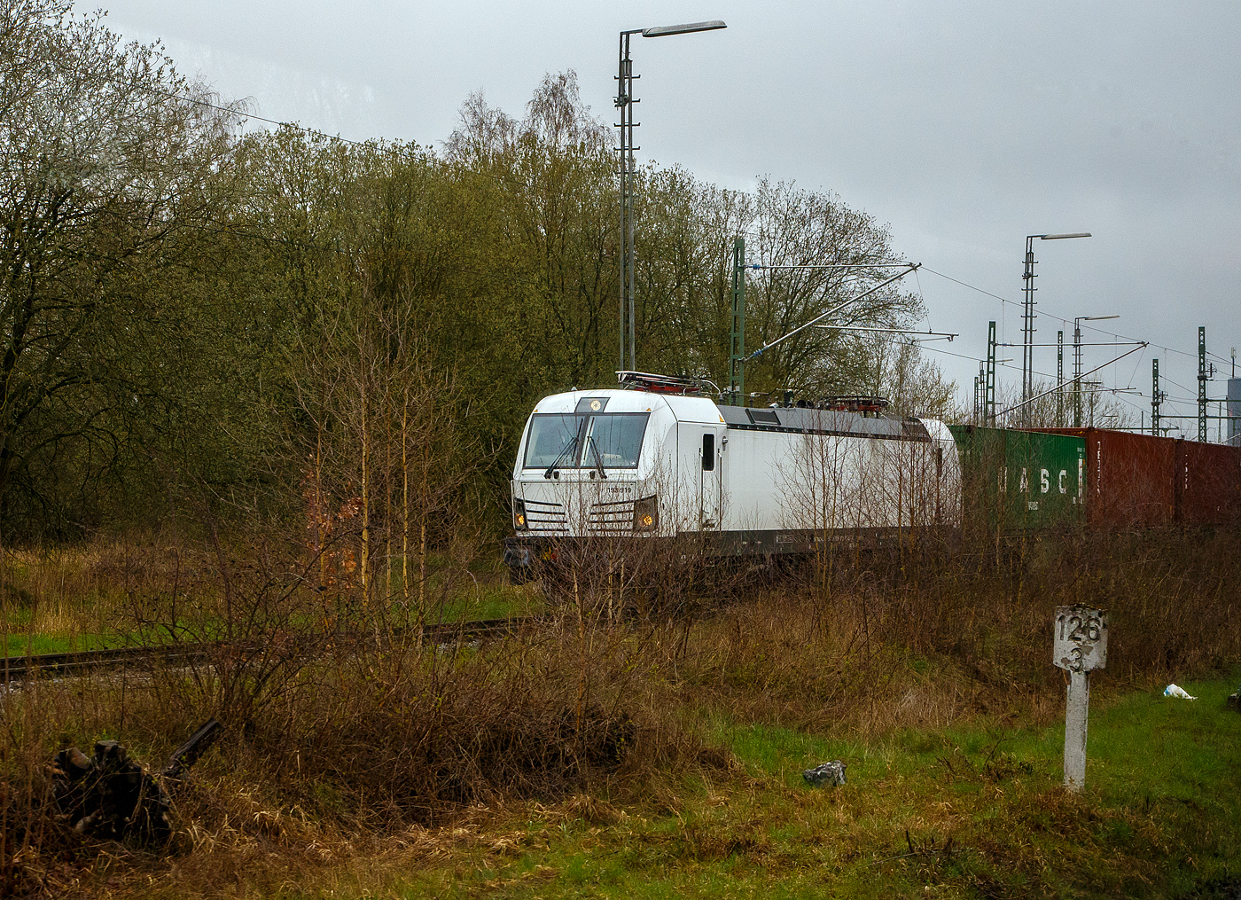 Die weiße SIEMENS Vectron AC DPM 193 919 (91 80 6193 919-8 D-ELOC) am 17.04.2023 mit einem Containerzug beim Hbf Hof. Bild aus einem Zug heraus.

Die SIEMENS Vectron AC DPM mit Diesel Power Modul  bzw. LM (Last Mile Diesel) wurde 2022 von Siemens Mobilitiy in München-Allach unter der Fabriknummer 22968 gebaut. Diese Vectron Lokomotive ist als AC DPM – Lokomotive (Wechselstrom-Variante mit Dieselmodul für Rangieren ohne Fahrdraht) mit 6.400 kW konzipiert und zugelassen für Deutschland, Österreich Ungarn und Rumänien (D/A/H/RO), im Dieselbetrieb beträgt die Leistung lediglich 180 kW (160 kW am Rad).