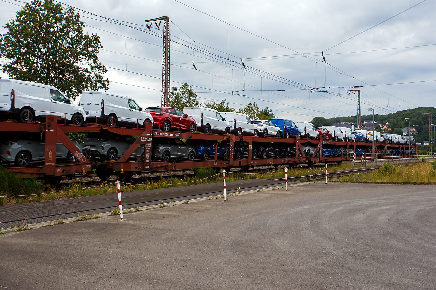 Doppelstock-Autotransportwagen 25 80 4367 693-5 D-ATG, der Gattung Laaeks 553, der DB Cargo Logistics GmbH (ex DB Schenker ATG) am 01 August 2024 im Zugverband bei der Zugdurchfahrt in Wilnsdorf-Rudersdorf (Kreis Siegen).

Der Wagen wurde 1988 von der Wagon Union (WU) in Berlin-Borsigwalde gebaut

Diese zuverlässigen und robusten Wagen dieser Bauarten wurden für den internationalen Transport von PKW entwickelt. Zur Be- und Entladung der oberen Ladeebene an Kopframpen können die Wagenenden aus der Transportstellung in die sogenannte Rampenstellung abgesenkt beziehungsweise angehoben werden. Des Weiteren können die Wagenenden der oberen Ladeebene in die Beladestellung angehoben werden. Hierdurch wird die maximale Durchfahrtshöhe für die Be- und Entladung der Fahrzeuge auf der unteren Ladeebene realisiert.

TECHNISCHE DATEN:
Gattung: Laaeks (Bauart 553)
Erstes Baujahr der Wagengattung: 1986
Spurweite: 1.435 mm
Anzahl der Achsen: 4
Länge über Puffer : 27.000 mm
Achsabstände: 9.000 / 4.300 / 9.000 mm
Ladelänge : 26.100 mm (unten) / 26.500 mm (oben)
Ladebreite : 3.000 mm (unten) / 2.910 mm (oben)
Wagenhöhe: 3.400 mm
Höchstgeschwindigkeit: 100 km/h (beladen) /120 km/h (leer)
Eigengewicht: 26.500 kg
Nutzlast: 18,5 t ab Streckenklasse A (unten max. 12 t / oben max. 10 t)
Kleinster befahrb. Gleisbogenhalbmesser: R = 80 m
Bremse: KE-GP (LL)
Bremssohle: IB 116
Intern. Verwendungsfähigkeit: RIV
