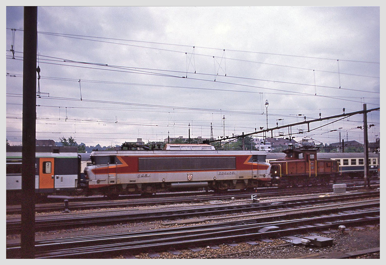 Ee 931 (Ee 3/3 II): Die Zweisystemlok (Wechselstrom SNCF 25 kV 50 Hz / SBB 15 kV 16,7 Hz) 16505  der SBB in einem ihrer typischen Dienste, nämlich das Vorziehen eines Zuges aus dem Bahnhof Basel SBB (15 kV 16,7 Hz), um ihn dann in den französischen Bahnhof Basel SNCF (25 kV 50 Hz) zurückzustellen, wo dann auch die SNCF Lok BB 15061 ihren Pantographen heben darf. Ein schöneres Bild einer solchen Szene wäre willkommen! 11.Mai 1989.  