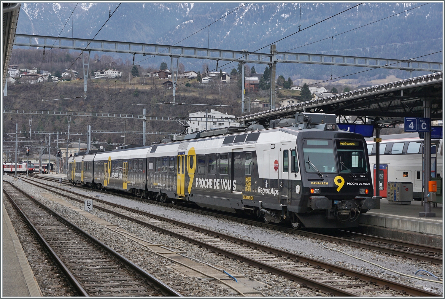Eigentlich eine  Pflicht-Aufnahme : der Region Alps Domino RBDe 560 414 mit Kanal 9 Werbung vermag nicht sonderlich zu begeistern. Hier wird der Triebwagen nach der Ankunft in Brig in einen anderen Bahnhofsteil rangiert.

2. Feb. 2024