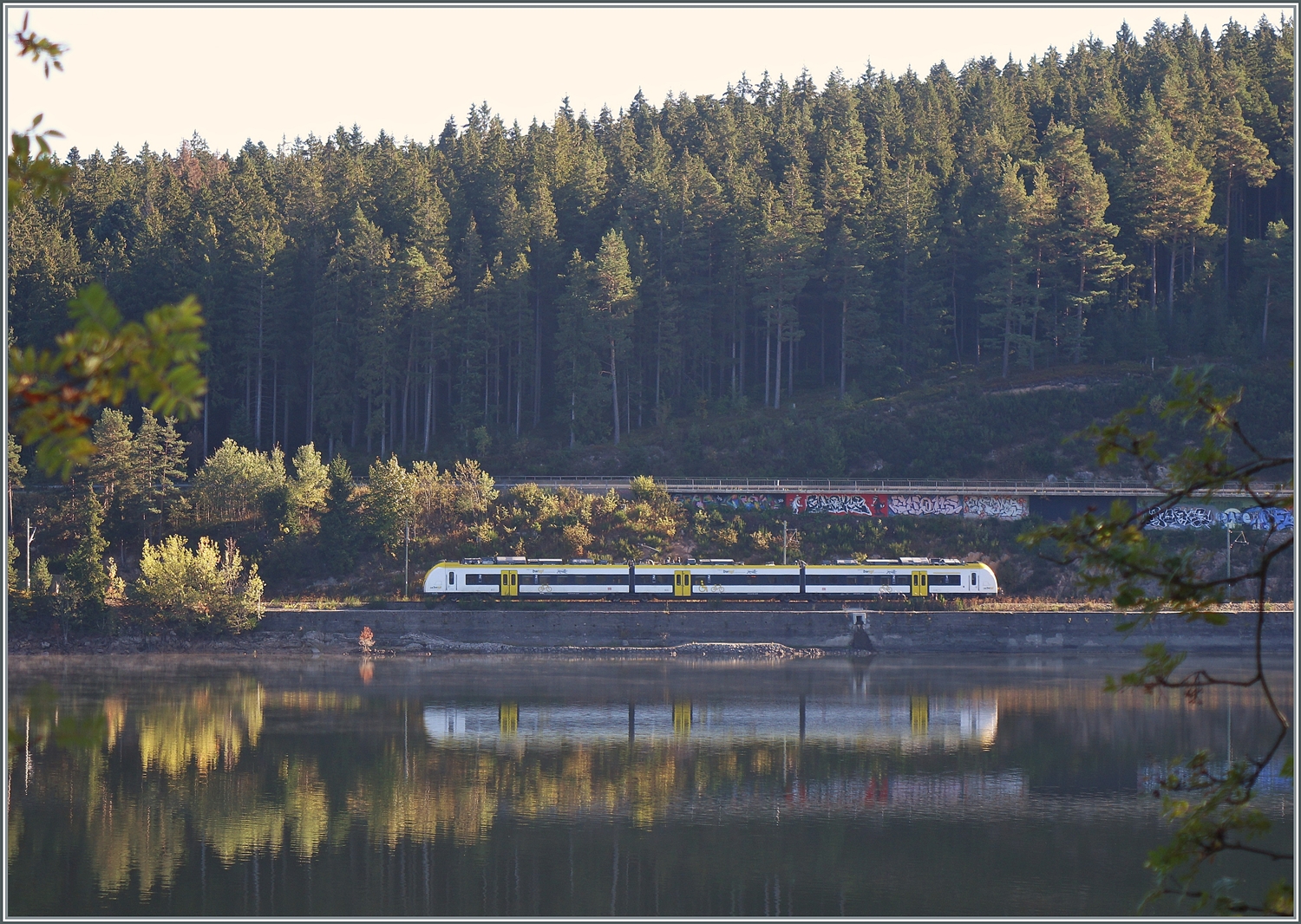 Ein Bild quer über den Schluchsee: ein DB 1440 ist zwischen Seebrugg und Schluchsee auf dem Weg nach Titisee.

25. Sept. 2023