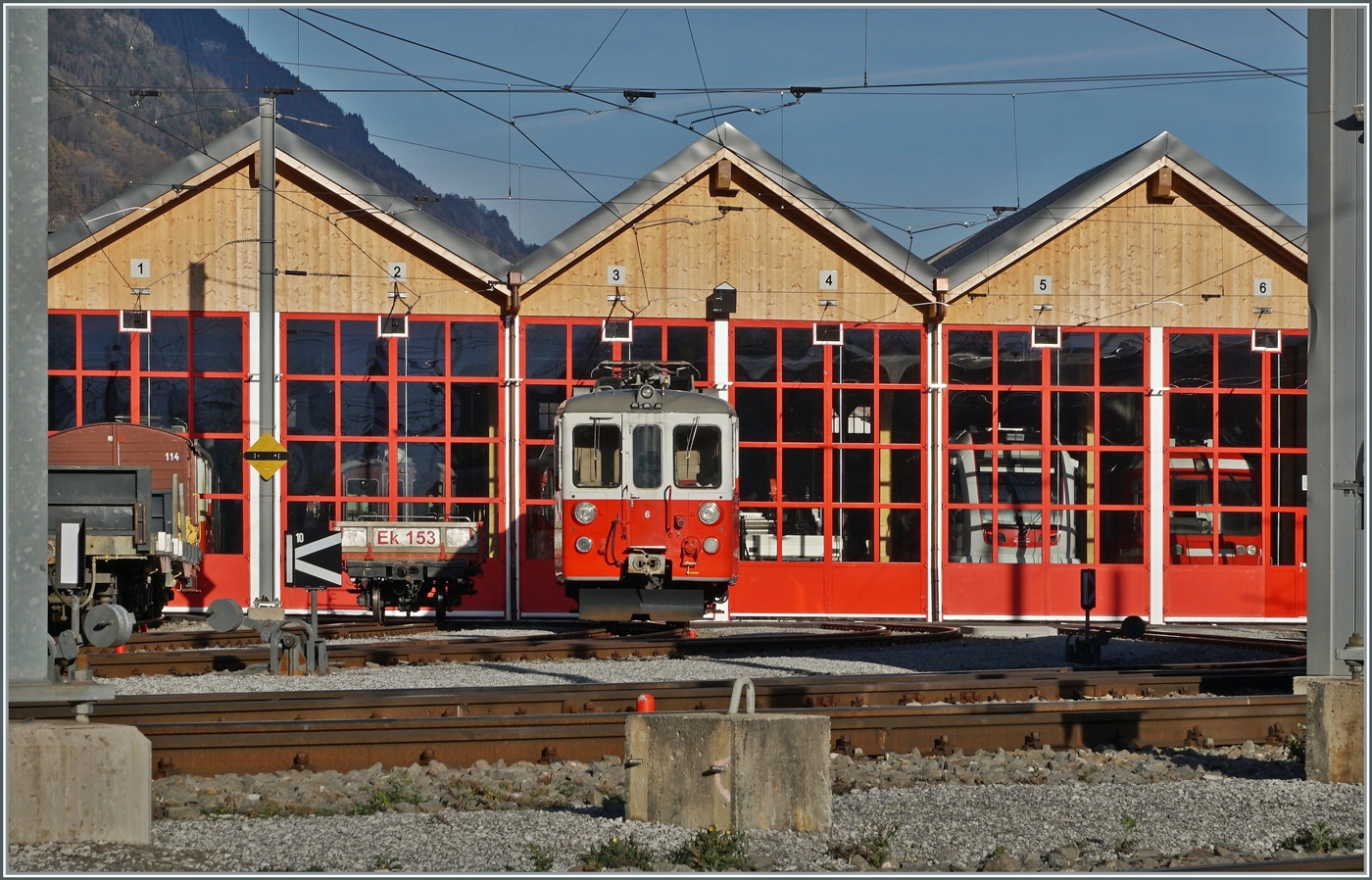 Ein Blick von der Zugangsstrasse über die Geleise auf das MC Dépôt in Vernayaz MC mit dem Xeh 4/4 N° 6 im Vordergrund. Und wer genau hinschaut entdeckt hinter den Schieben der geschlossen Tore allerlei interessantes. Doch zu meiner Enttäuschung stand nicht, wie letzte Woche kurz gesehen, einer der neuen Beh 4/8 VOR dem Dépôt. 

19. November 2025
