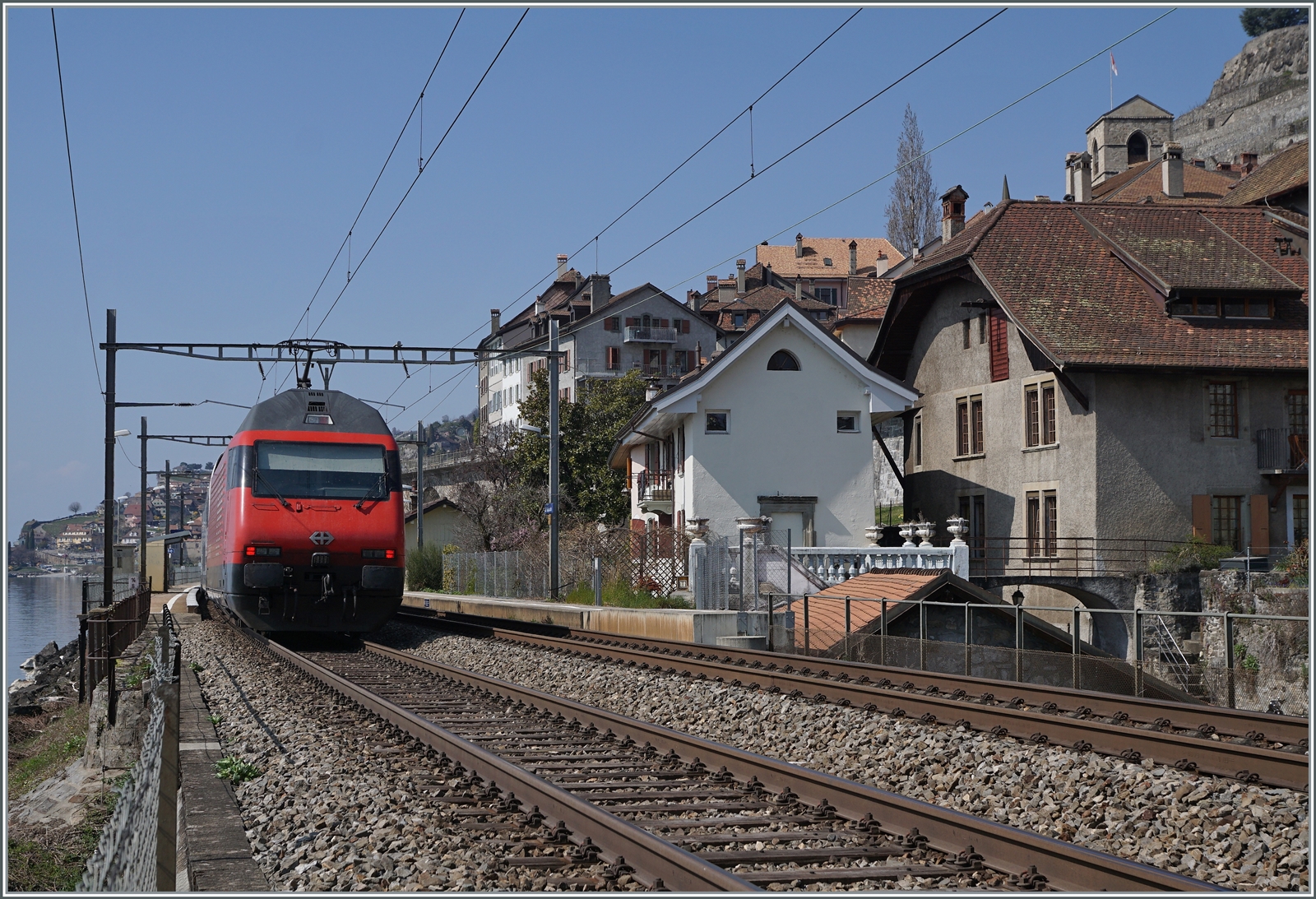 Eine SBB Re 460 ist mit ihrem IR90 bei St-Saphorin auf dem Weg nach Genève Aéroport. 

25. März 2022