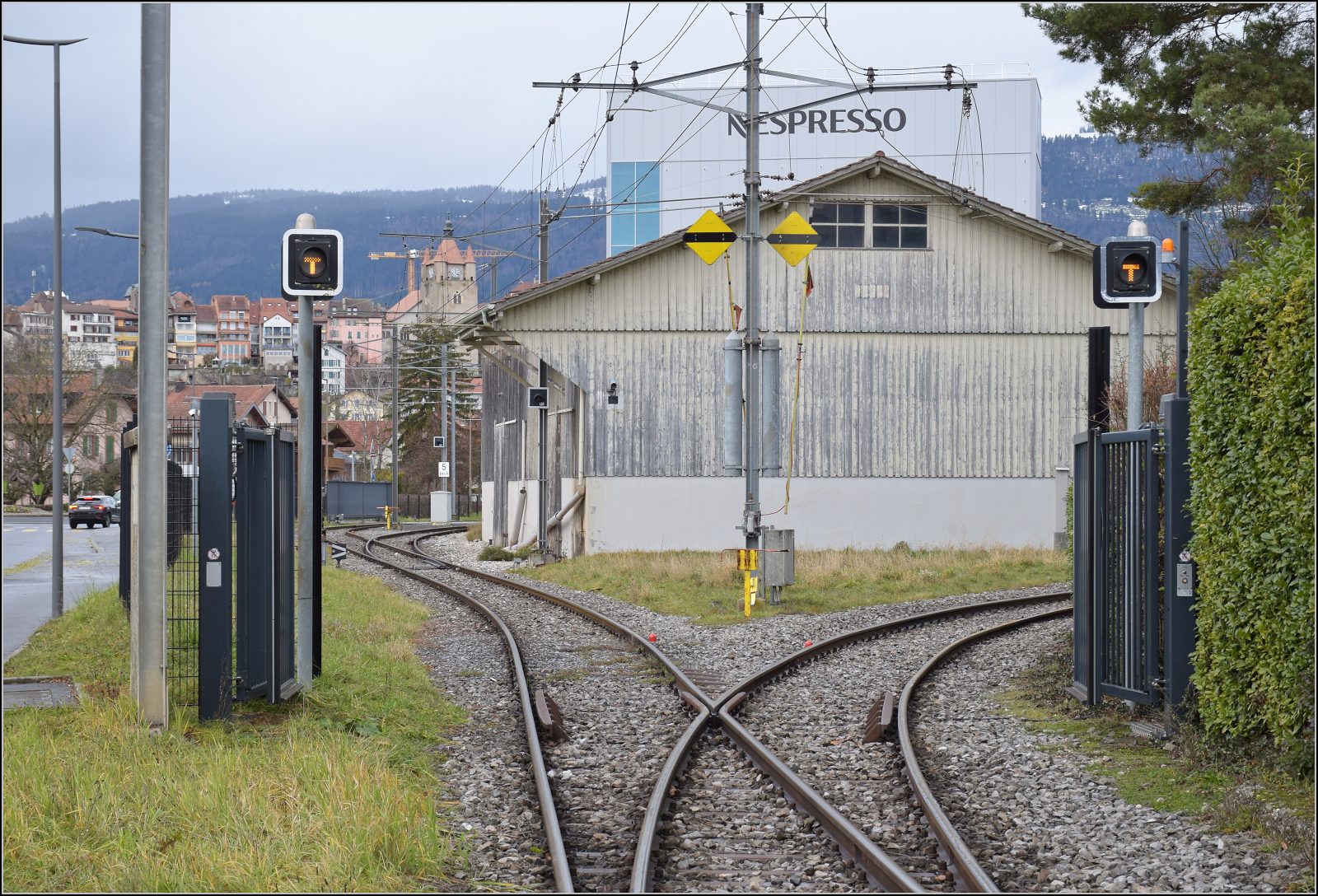 Ende einer Ära. 

Tag der offenen Tore, so scheint es zumindest am Anschluss des Werksgleises von Nestlé in Orbe. Dezember 2025. Deutlich erkennt man noch die Niederspannungselektrifizierung des Werksgeländes, wenngleich die Verdieselung des Güterverkehrs auf der OC die Führung der Oberleitung über die Strasse längst verschwinden ließ.