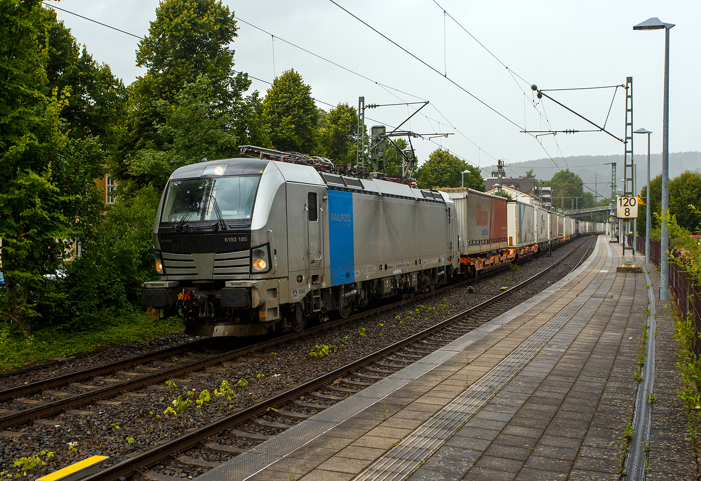Es begann zu regnen und wir wollten schon den Heimweg antreten, da ging die Schranke am Bü herunter, das kann nur ein Güterzug sein, so ich ging wieder an den Bahnsteig. Die Siemens Vectron MS 6193 185 (91 80 6193 185-6 D-Rpool) der Railpool GmbH (München) fährt am 16 Juli 2025 mit einem KLV-Zug durch den Bahnhof Kirchen/Sieg in Richtung Köln. Nochmals einen lieben Gruß an den freundlichen Lokführer zurück.

Die Multisystemlokomotive Siemens Vectron MS wurde 2024 von SIEMENS Mobilitiy in München-Allach unter der Fabriknummer 23485 gebaut. Sie wurde in der Variante MS A54 ausgeführt und hat so die Zulassungen und Länderpakete für Deutschland, Österreich, Belgien, die Niederlande, Tschechien, die Slowakei, Ungarn, Rumänien und Polen. Für Serbien (SRB), Bulgarien (BG) und Kroatien (HR) sind auch Zulassungen vorgesehen, aber ist z.Z. noch durchgestrichen.

So besitzt die Variante MS A54 folgende Zugsicherungssysteme: ETCS BaseLine 3, sowie für Deutschland (PZB90 / LZB80 (CIR-ELKE I)), für Österreich (ETCS Level 1 mit Euroloop, ETCS Level 2, PZB90 / LZB80), für Belgien (ETCS L1, ETCS L2, TBL1+), für die Niederlande (ETCS Level 1, ETCS Level 2, ATB-EGvV), für Tschechien und die Slowakei (LS (Mirel)), für Ungarn (ETCS Level 1, EVM (Mirel)), für Polen (SHP) und für Rumänien, Serbien, Bulgarien und Kroatien (PZB90).