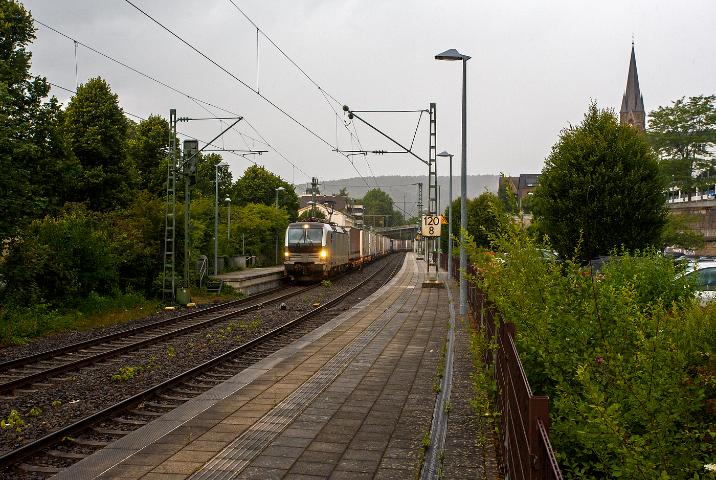 Es begann zu regnen und wir wollten schon den Heimweg antreten, da ging die Schranke am Bü herunter, das kann nur ein Güterzug sein, so ich ging wieder an den Bahnsteig. Die Siemens Vectron MS 6193 185 (91 80 6193 185-6 D-Rpool) der Railpool GmbH (München) fährt am 16 Juli 2025 mit einem KLV-Zug durch den Bahnhof Kirchen/Sieg in Richtung Köln. Nochmals einen lieben Gruß an den freundlichen Lokführer zurück.

Die Multisystemlokomotive Siemens Vectron MS wurde 2024 von SIEMENS Mobilitiy in München-Allach unter der Fabriknummer 23485 gebaut. Sie wurde in der Variante MS A54 ausgeführt und hat so die Zulassungen und Länderpakete für Deutschland, Österreich, Belgien, die Niederlande, Tschechien, die Slowakei, Ungarn, Rumänien und Polen. Für Serbien (SRB), Bulgarien (BG) und Kroatien (HR) sind auch Zulassungen vorgesehen, aber ist z.Z. noch durchgestrichen.

So besitzt die Variante MS A54 folgende Zugsicherungssysteme: ETCS BaseLine 3, sowie für Deutschland (PZB90 / LZB80 (CIR-ELKE I)), für Österreich (ETCS Level 1 mit Euroloop, ETCS Level 2, PZB90 / LZB80), für Belgien (ETCS L1, ETCS L2, TBL1+), für die Niederlande (ETCS Level 1, ETCS Level 2, ATB-EGvV), für Tschechien und die Slowakei (LS (Mirel)), für Ungarn (ETCS Level 1, EVM (Mirel)), für Polen (SHP) und für Rumänien, Serbien, Bulgarien und Kroatien (PZB90).