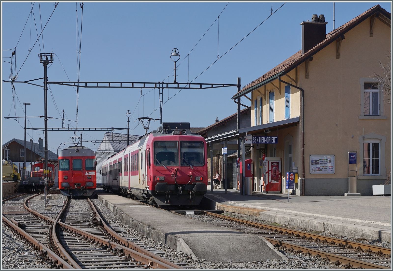 Gleich vorne weg: Das Bild entstand auf dem wieder geöffneten Bahnübergang. Zum Bild selbst: in Sentier Orient begegnet der TRAVYS RBDe 560 384-0 (RBDe 560 DO TR 94 85 7560 384-0 CH-TVYS)  Lac de Brenet  dem hier für einige Stunden abgestellten  Schülerzug  bestehend aus TRAVYS RBDe 567 174 (94 85 7567 174-8)  Fleurier , dem B 536 (B 50 85 2035 536-5 CH-TVYS) und dem ABt 375 (ABt 50 85 80 33 325-7), der infolge des in Le Brassus angekommen Güterzuges keinen Platz mehr fand.

24. März 2022