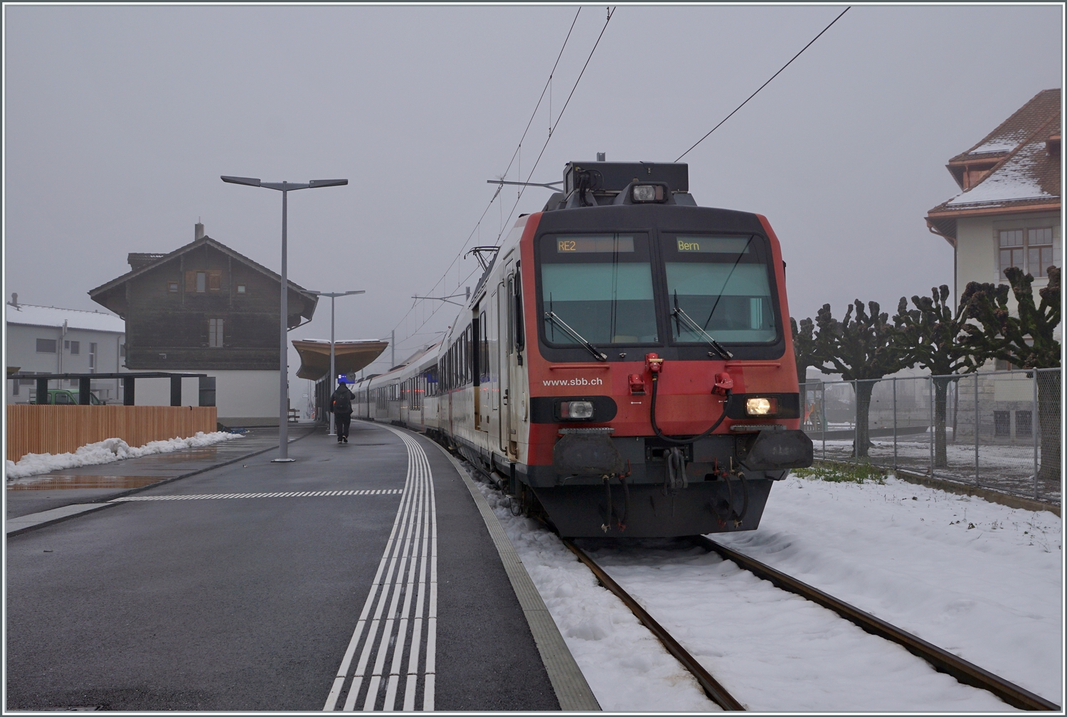 Gute zwei Jahre später stehe ich praktisch an der selben Stelle, wieder ist es neblig, aber sonst hat sich viel getan: ein SBB RBDe 560 ist als RE2 von Bulle kommend in Broc Village angekommen. Der Zug wird als RE2 nach gut zehn Minuten nach Bern abfahren. Die weiterführende Strecke nach Broc Fabrique (hinter meinem Rücken) ist noch immer im Umbau, so dass die kleine Station Broc Village für eine paar Monate zur Zugsend- und Ausgangstation wird.

15. Dezember 2022