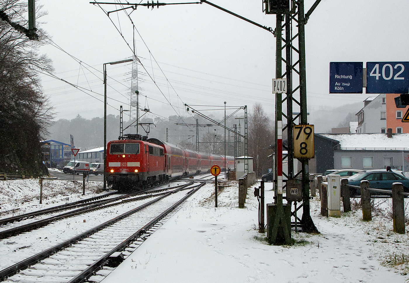 Heute hat es etwas geschneit und es schneit noch.... 
Die 111 168-1 (91 80 6111 168-1 D-DB) der DB Regio NRW rauscht am 19.01.2023 mit dem RE 9 rsx - Rhein-Sieg-Express (Aachen – Köln – Siegen), etwas verspätet durch den Bahnhof Scheuerfeld (Sieg) in Richtung Betzdorf.

Die Lok wurde 1980 von Henschel & Sohn in Kassel unter der Fabriknummer 32441 gebaut. Aktuell wird sie DB Gebrauchtzug am Markt zum Kauf angeboten.