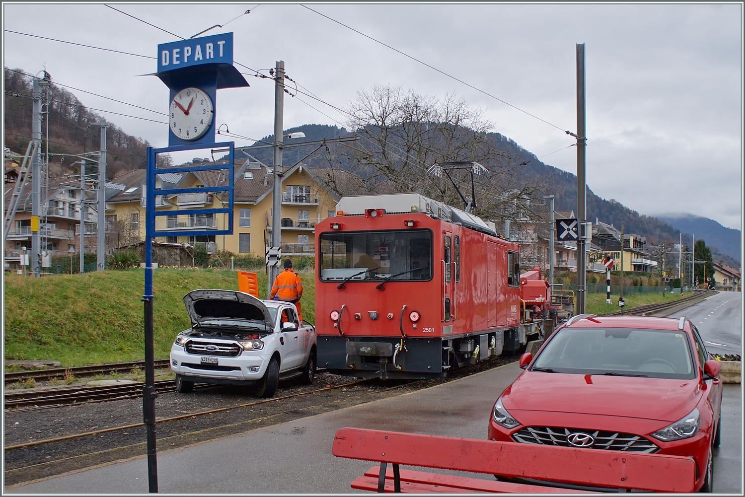 HGem 2/2 2501 nennt sich die Lok im Vordergrund; und das Auto mitten auf den Schienen im Bahnhof von Blonay kümmert sich um das  m  in der Lokbezeichnung: Die Lok wird betankt!

1. März 2024