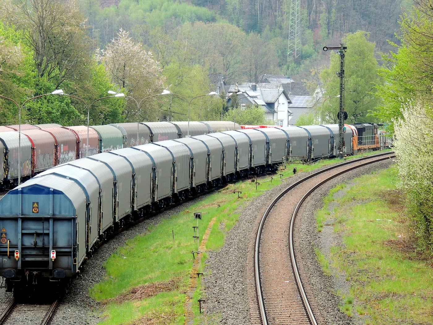 Hochbetrieb in Herdorf am 23 April 2025:
Zuvor hatten ja schon die KSW 44 und die nachschiebende KSW 47 mit sehr langen Coilzug den KSW-Rangierbahnhof in Herdorf (Betriebsstätte FGE - Freien Grunder Eisenbahn) erreicht.

Nun hat auch die die KSW 43 (92 80 1273 018-2 D-KSW), die asymmetrische Vossloh G 2000 BB, mit einem langen Coilzug (VTG Coilwagen der Gattung Shimmns-ttu, VTG Bez. F46.520D) vom Hafen Duisburg kommend den Rbf erreicht.

Den Zug übernimmt gleich die KSW 44, die diesen dann Teil weiter zu den Schäfer Werke KG am Pfannenberg in Neunkirchen-Salchendorf, da wegen den Achslasten dafür besser geeignet ist. Die KSW 43 und die KSW 47 fahren später gemeinsam als Lokzug zurück in Richtung Betzdorf/Sieg. 