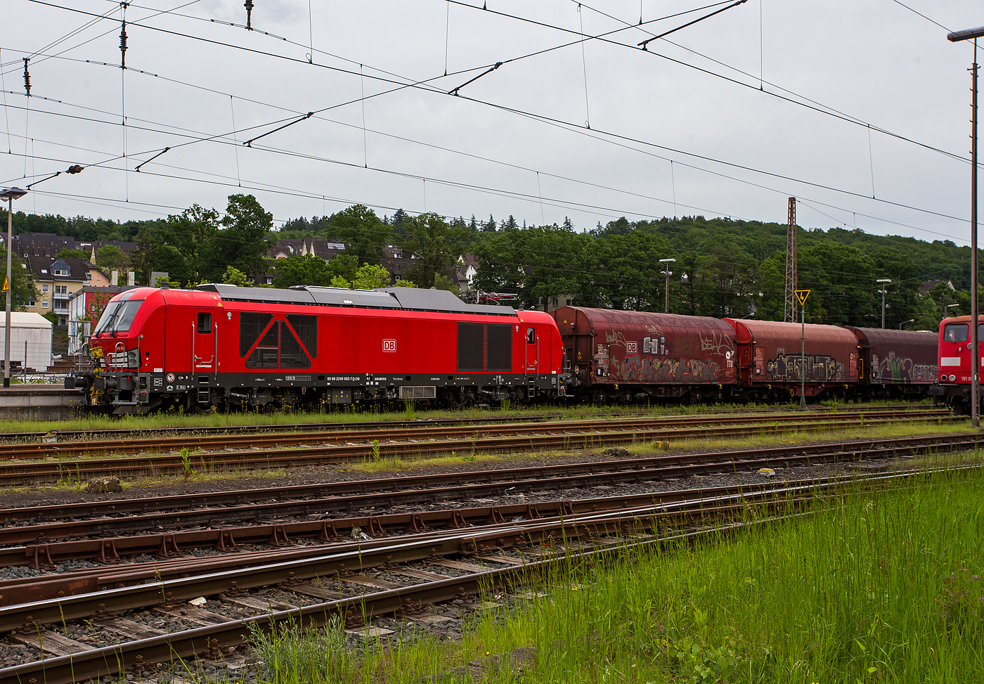 Ich war schon überrascht dass ich diese neuen Zweikraftlokomotiven „Siemens Vectron Dual Mode light“ (BR 249) der DB Cargo AG in Kreuztal nun schon sehen konnte und dann auch gleich 3 Stück. Am 21 Mai 2024 waren hier die 249 002-7 (0 80 2249 002-7 D-DB), die 249 003-5 (90 80 2249 003-5 D-DB) und die 249 006-8 (90 80 2249 006-8 D-DB).

Hier drückt die 249 002-7 (0 80 2249 002-7 D-DB) der DB Cargo AG einen Güterzug im Last-Mile-Modus (mit Dieselantrieb) vom Abstellbereich beim Bahnhof Kreuztal zum Rangierbahnhof (Rbf Kreuztal). Da hier Oberleitungen vorhanden sind, wäre eigentlich der Last-Mile-Modus (Dieselantrieb) nicht nötig, aber vermutlich war es ein Test- bzw. Schulungsbetrieb.

Die Vectron Dual Mode light 249 002-7 der Baureihe 249 wurden 2022 von Siemens Mobility GmbH in München-Allach unter der Fabriknummer 23060 gebaut. Die Lok war von Ende Mai 2022 erst durch Siemens Mobility GmbH, als 90 80 2249 002-7 D-SDEHC registriert/eingestellt. Erst nach der Abnahme durch die DB Cargo und den Verkauf an diese im März 2024 wurde sie als 90 80 2249 003-5 D-DB eingestellt. Die Loks der Baureihe 249 haben die Zulassung für Deutschland und eine Höchstgeschwindigkeit von 120 km/h.

Diese Lokomotivbaureihe wird man bald auf deutschen Gleisen wohl oft sehen können. Denn die DB Cargo erneuert seine Rangier- und Strecken-Lokflotte und beschafft neue Zweikraftlokomotiven der BR 249, als Ersatz für die älteren Diesellokomotiven der Reihe 294 (V 90). Es wurde Rahmenvertrag mit dem Hersteller Siemens Mobility über bis zu 400 Fahrzeuge, die einem Investitionsvolumen von deutlich über einer Milliarde Euro entsprechen, angeschlossen. Geliefert werden Lokomotiven vom Typ Vectron Dual Mode light mit spezifischen Anpassungen für das von DB Cargo geplante Einsatzspektrum. 
Zunächst bestellt die DB Cargo 150 Loks der Baureihe 249. Diese DB Loks sind aber stark modifiziert, so beträgt bei ihnen die Achslast maximal 21 t (statt 22,5 t). Sie besitzen in den Führerständen jeweils einen zusätzlichen Seitenfahrschalter sowie ein Schwanenhalsmikrofon. Weitere Unterschiede sind die Ausrüstung mit Rangierkupplungen Rk900, Rangiertritten neben den Puffern, zusätzlichen Überwachungskameras zur Überwachung des Raumes zwischen den Lokomotiven und Warnleuchten für den Betrieb mit Funkfernsteuerung.

Die Loks der Baureihe 249 (Vectron Dual Mode light) besitzen gegenüber der BR 248 einem kleineren Dieselmotor von Cummins (QST 30-L) mit einer Leistung von 950 kW (anstatt des MTU 16V 4000 R84 mit 2.400 kW Leistung). Allein durch den kleineren Motor wurden ca. 5,5 t Gewicht eingespart.  So ist die speziell für die Anforderungen von DB Cargo optimierte „Vectron Dual Mode light“ imehrere Tonnen leichter als herkömmliche Modelle und kann so auch auf Nebenstrecken und Gleisanschlüssen mit geringerer Traglast eingesetzt werden. Diese Eigenschaften machen sie besonders geeignet für den Einzelwagenverkehr, der durch die Reduzierung des Lokwechsels schneller und effizienter wird-

TECHNISCHE DATEN der Vectron Dual Mode light (BR 249)
Einsatzbereich: Güterverkehr und Zugbildung
Spurweite: 1.435 mm (Normalspur)
Achsformel: Bo'Bo'
Länge über Puffer: 20 510 mm
Drehzapfenabstand: 10.800 mm
Achsabstand im Drehgestell: 2.700 mm
Breite: 3.020mm
Höhe:  4.220 mm
Raddurchmesser : 1.100 mm (neu) / 1.020 mm (abgenutzt)
Gewicht:  84 t (bei vollen Vorräten)
Achslast: 21 t
Spannungssysteme (bei E-Betrieb): 15 kV, 16,7 Hz
Dieselmotor: Gedrosselten  V12-Zylinder -Viertakt-Dieselmotor mit Turboaufladung und Ladeluftkühlung, vom Typ Cummins QST 30-L
Dieselmotorleistung an der Kurbelwelle (gedrosselt): 950 kW (1.291 PS)
max. Dieselmotorleistung (Kw): 1.119 kW (1.521 PS)
Motorhubraum 30,5 Liter (Bohrung 140 mm x Hub 165 mm)
Dieselmotor Nenndrehzahl: 2.100 U/min
Dieselmotor Motorgewicht (trocken): 3.555 kg
Max. Leistung am Rad E-Antrieb: 2.210 kW  (3.005 PS)
Max. Leistung am Rad Dieselbetrieb: 750 kW (1.020 PS) / max. 926 kW möglich
Höchstgeschwindigkeit:120 km/h
Antriebsart: elektrisch oder dieselelektrisch
Kraftübertragung: Teilabgefederter Antrieb (Ritzelhohlwellenantrieb)
Kraftstoffbehälter Nutzvolumen: 1.500 Liter
Anfahrzugskraft:  300 kN
Elektrische Bremskraft: 150 kN
Elektrische Bremsleistung (am Rad): E-Betrieb 2.210 kW / Dieselbetrieb 1.000 kW
Doppeltraktion: Über WTB ÖBB mit typgleichen Fahrzeugen 
Zugsicherung: PZB / für ETCS vorbereitet
