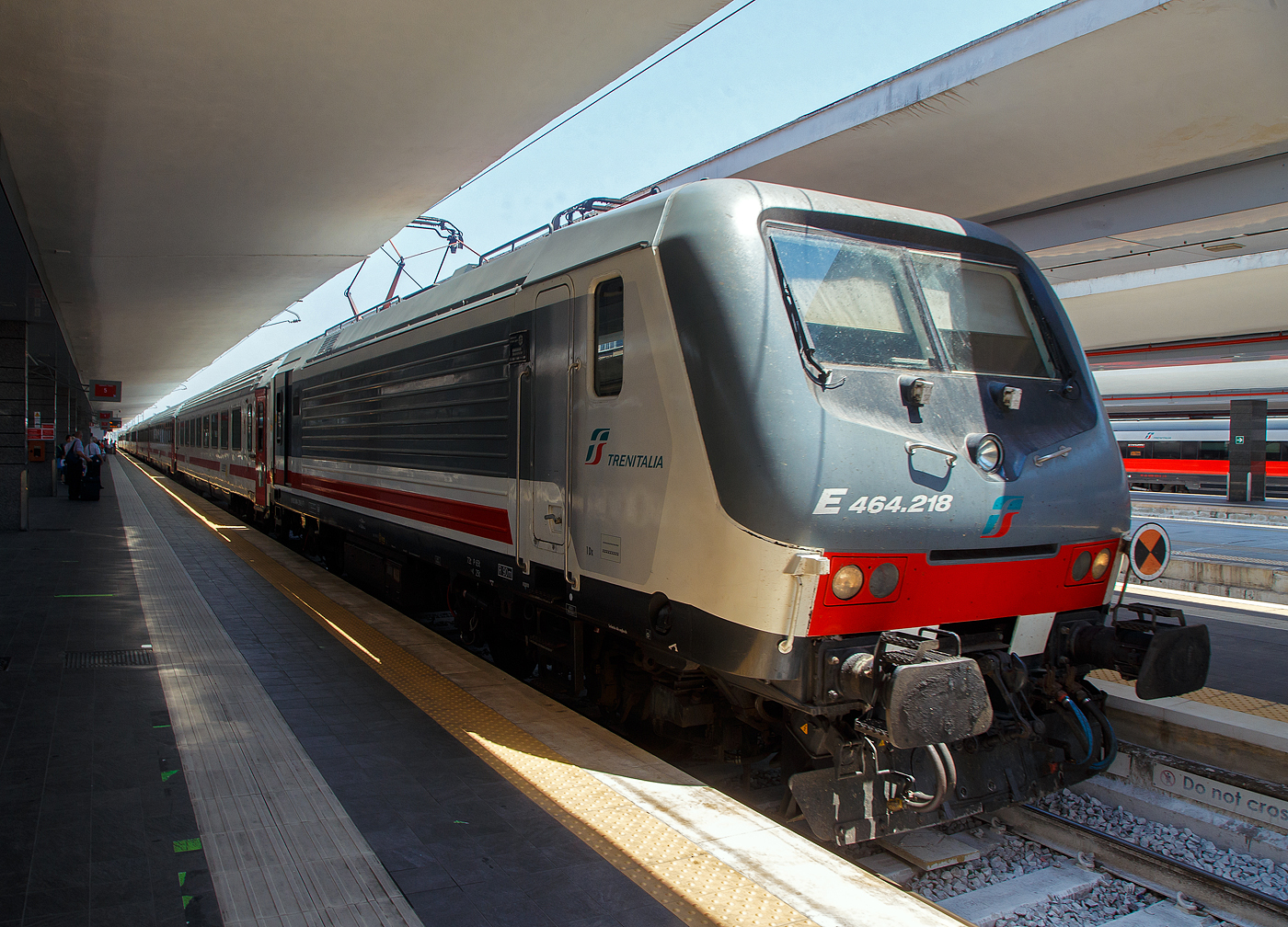 Im Sandwich zweier E.464 (geführt von der E.464.218), Steuerwagen an Steuerwagen erreicht unser Trenitalia Intercity 727 „SCILLA“ (Roma Termini - Napoli Centrale - Villa S. Giovanni - Messina Centrale - Syrakus (Siracusa) / Palermo) am 16.07.2022 den Bahnhof Napoli Centrale. 

Bis Villa S. Giovanni wird der Zug im Sandwich Steuerwagen an Steuerwagen gefahren, dann wird der Zug auf eine Eisenbahnfähre verladen und es geht über die Straße von Messina nach Sizilien. Nach der Entladung in Messina Centrale fährt der eine Zugteil weiter nach Palermo und der andere über Catania Centrale nach Syrakus (Siracusa). 